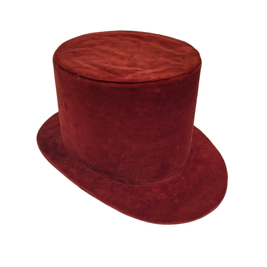 Exquisite high-top hat made of soft maroon velvet with a lined interior. Short, curved brim, slightly inclined. Due to its morphology, we estimate that it is a piece from the beginning of the 20th century, around the years 1910 and 1920.

The