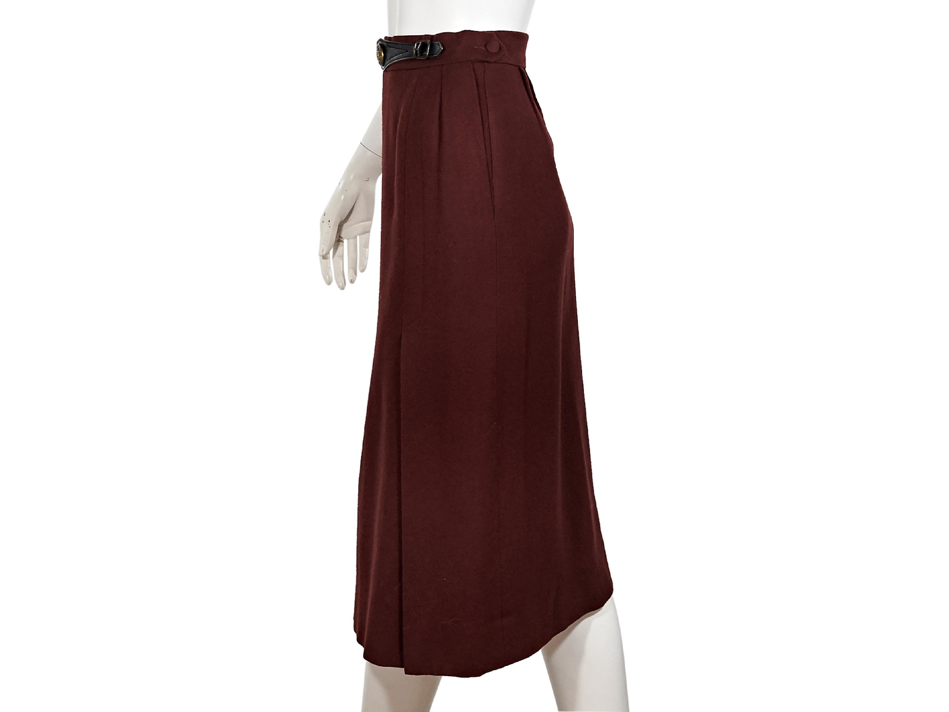 Product details:  Vintage burgundy wool skirt by Hermes.  Banded waist with belt-front accent.  Concealed side zip closure.  Waist button flap pocket.  Front hem vents.  Label size FR 36.  25