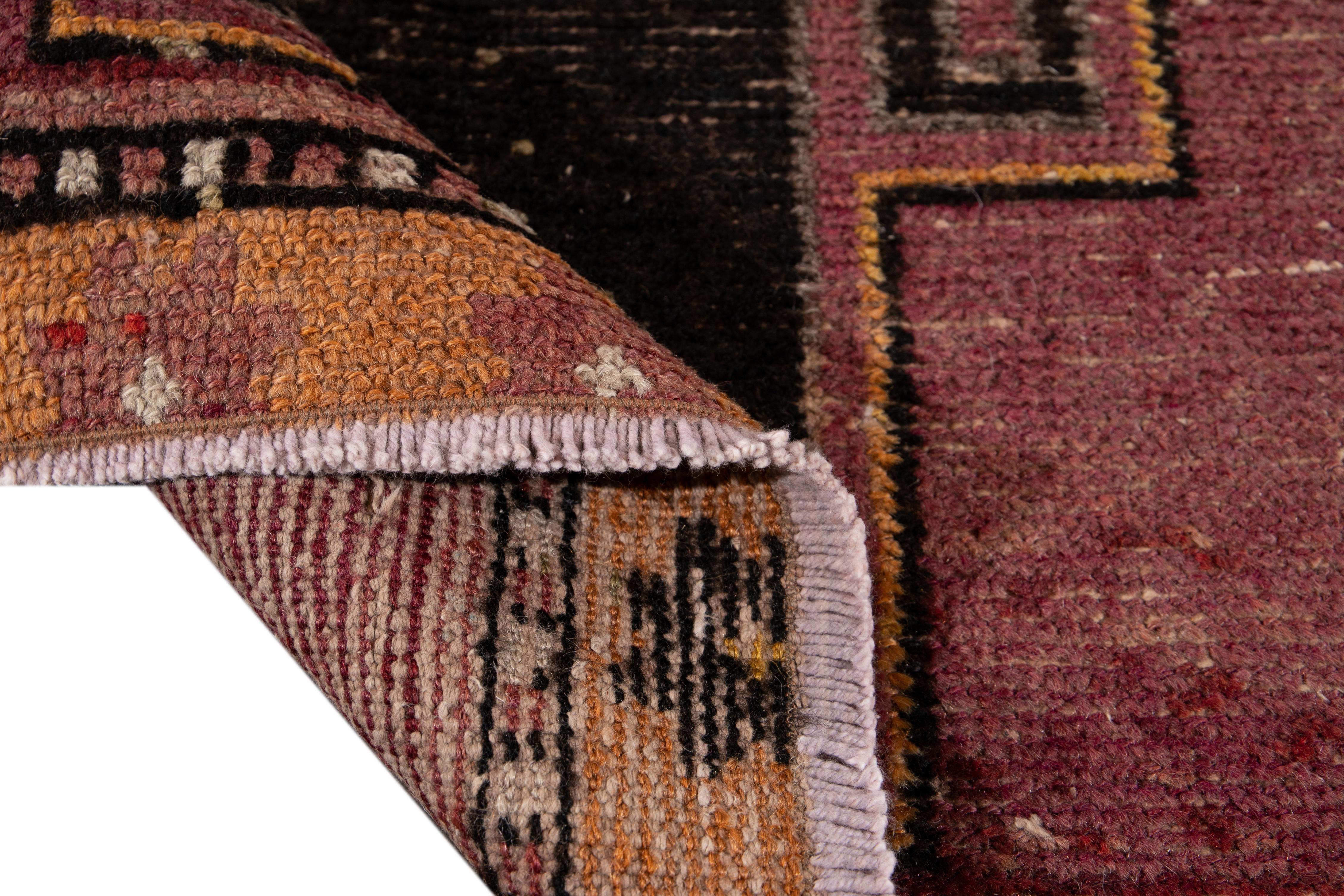 Beautiful vintage Turkish hand knotted wool rug with a burgundy field. This rug has accents of black, orange, and brown in a gorgeous all-over geometric Tribal design,

This rug measures: 3' x 9'2