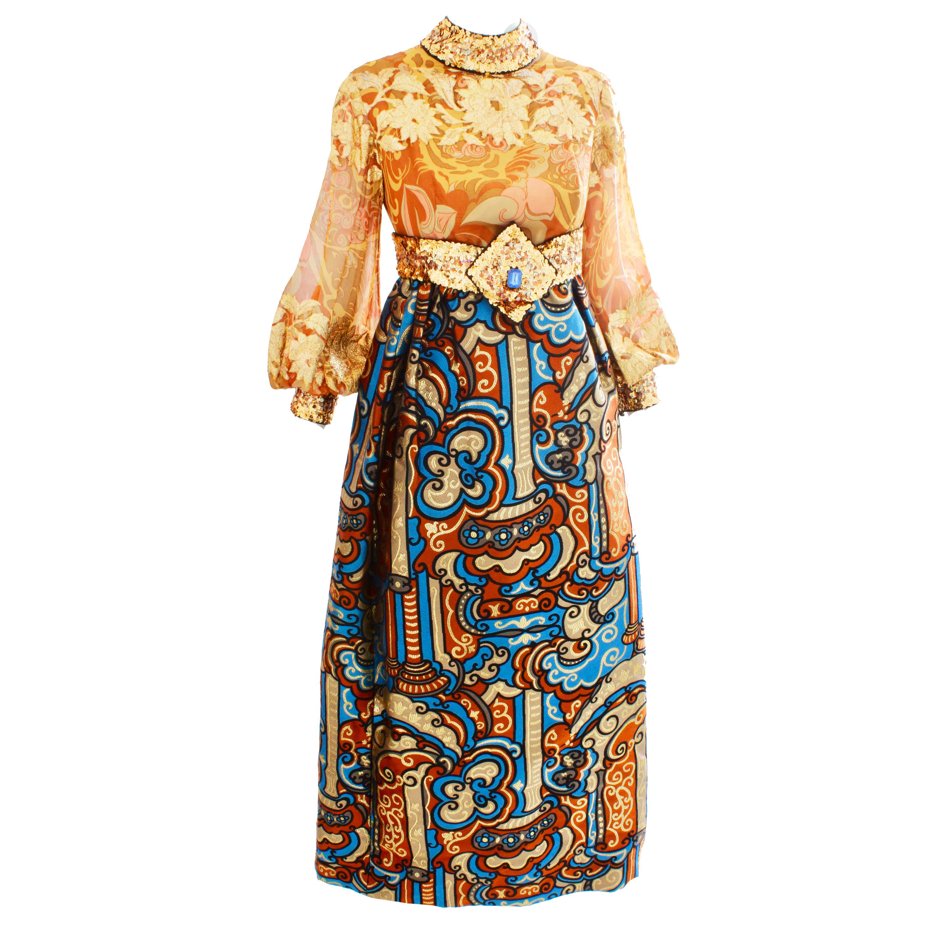 A timeless Burke Amey evening gown, likely made in the early 70s.  Made from gold silk, the bodice features an abstract floral pattern with embroidered metallic thread and bishop sleeves that fasten with silk covered buttons.  The attached skirt is