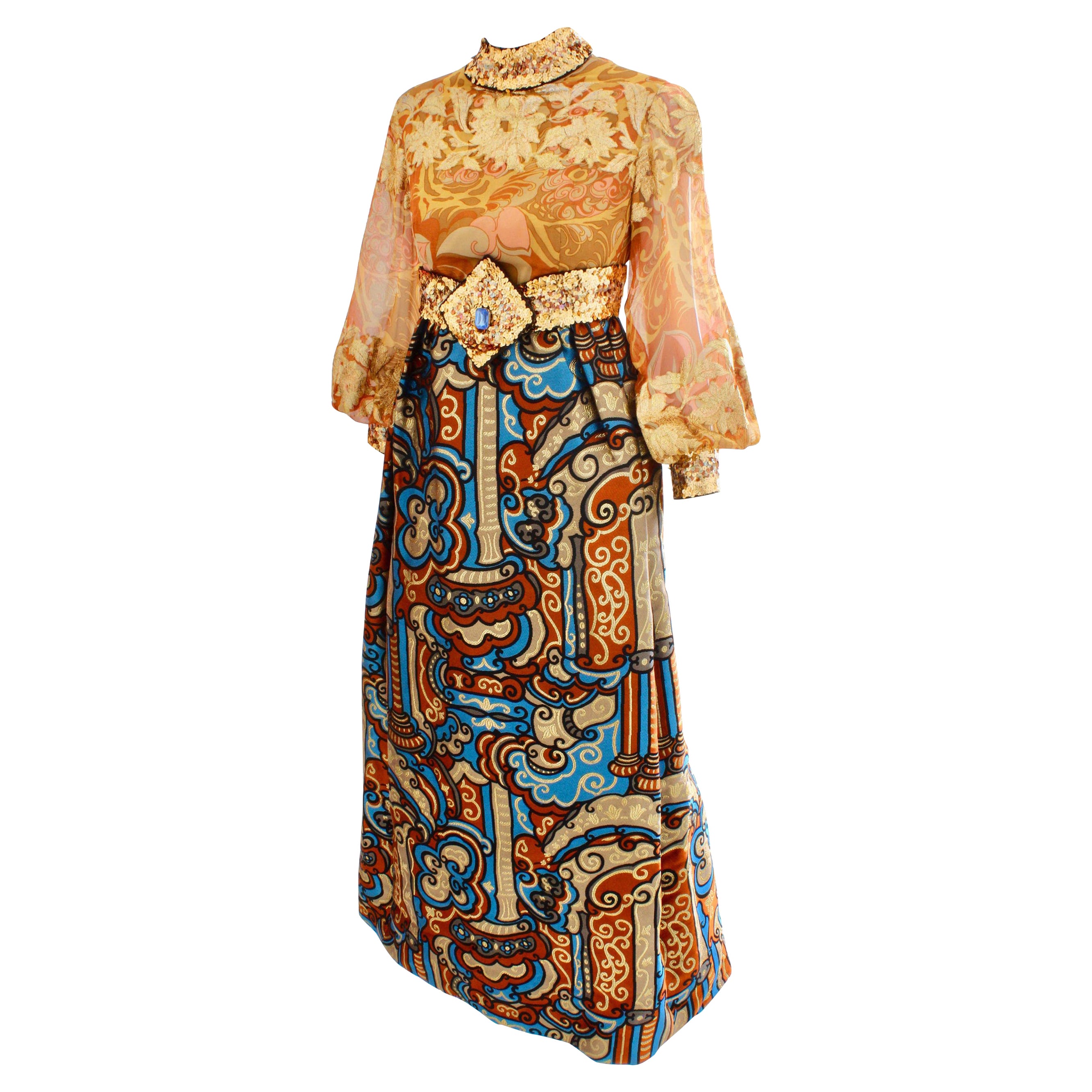 Ein zeitloses und exquisites Burke-Amey-Couture-Abendkleid, wahrscheinlich aus den späten 60er/Anfang der 70er Jahre.  Das aus goldfarbener Seide gefertigte Mieder zeigt ein abstraktes Blumenmuster mit gesticktem Metallfaden und Läuferärmel, die mit