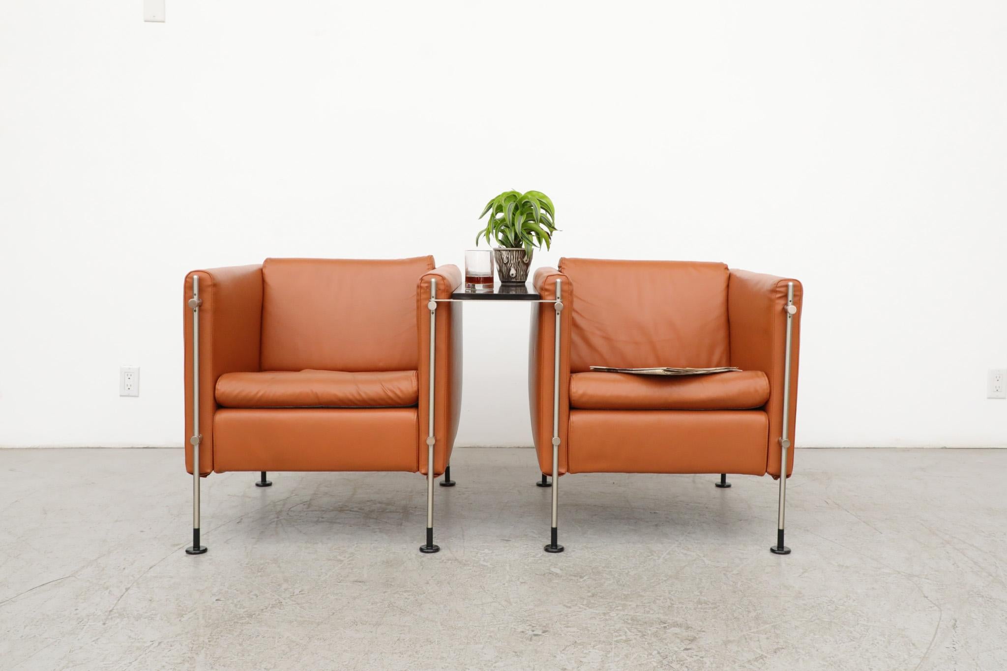 Impressive pair of mid-century, burnt orange colored, ‘Felix' lounge chairs designed by Burkhard Vogtherr for Italian furniture maker Arflex, a leading voice in Italian design since 1947. This set was manufactured in 1985 and has faux leather seats