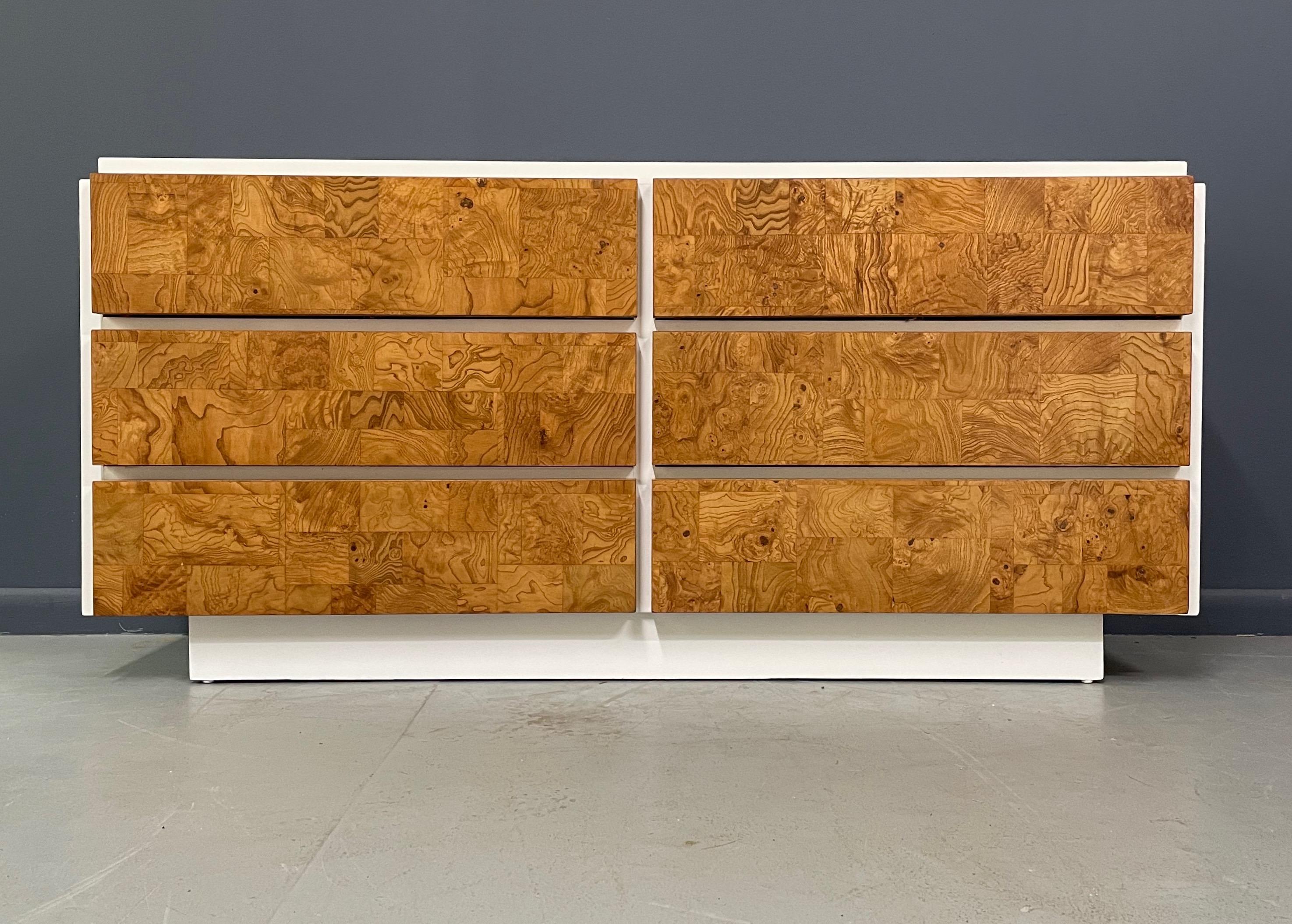 This really great dresser has a white lacquer case and patchwork burl drawer fronts.