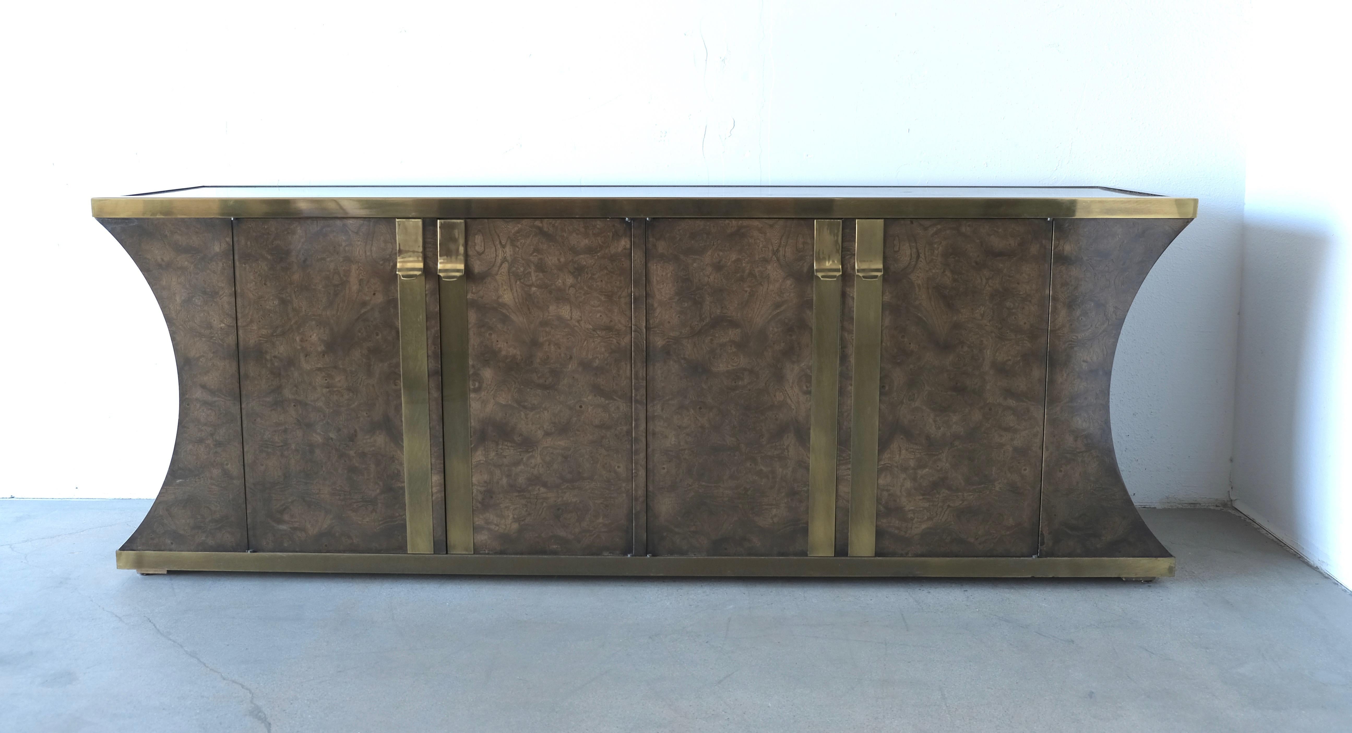 Beautifully figured burl on this Mastercraft credenza from the 1970s.
The aged brass which trims the top and base has a pleasing patina to it.
The brass hardware is a nice contrast to the burl wood. There are two sets of doors. The right pair