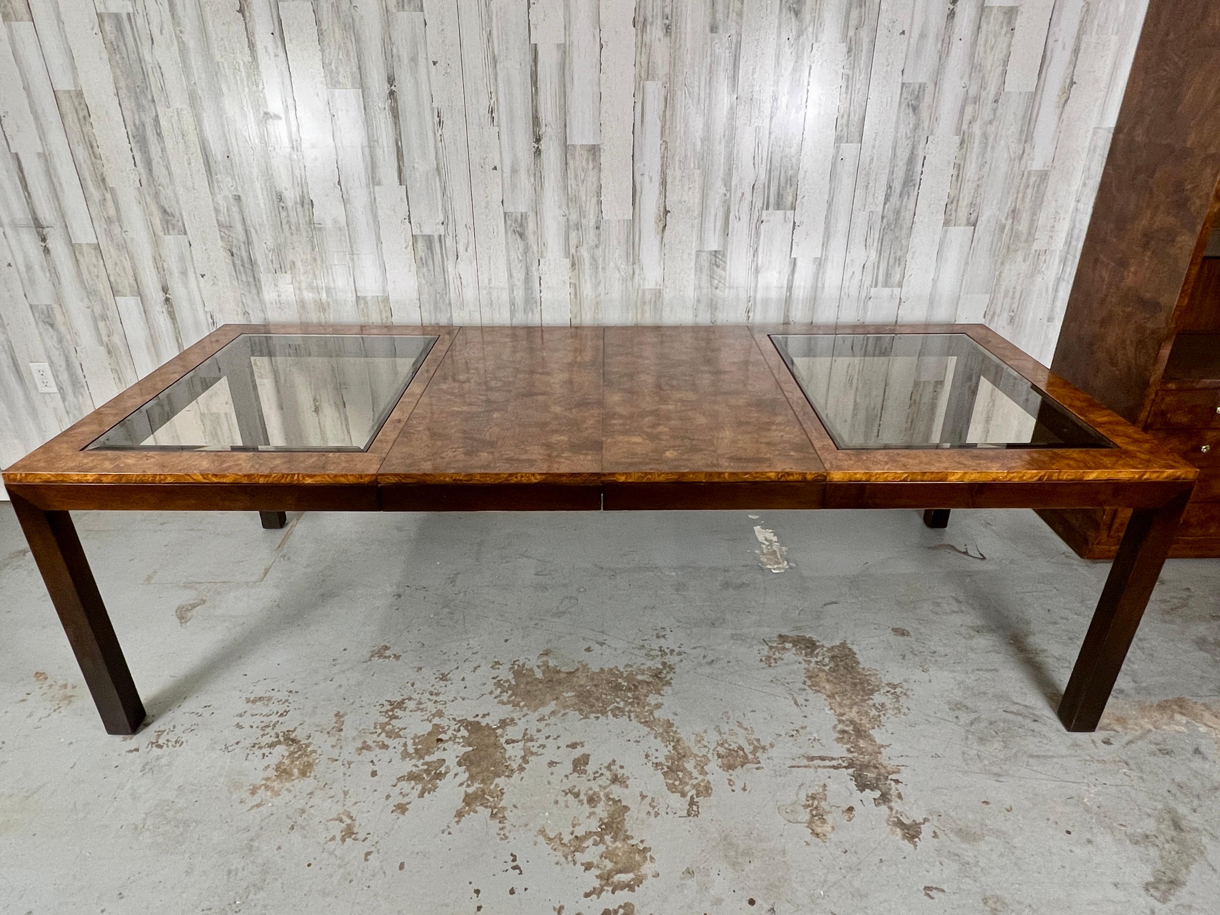 Table de salle à manger extensible en loupe et verre fumé par Century Furniture. Cette table est une véritable prouesse pour quelqu'un qui aime recevoir beaucoup d'invités. Incroyable bois de ronce avec des inserts en verre fumé sur le dessus.