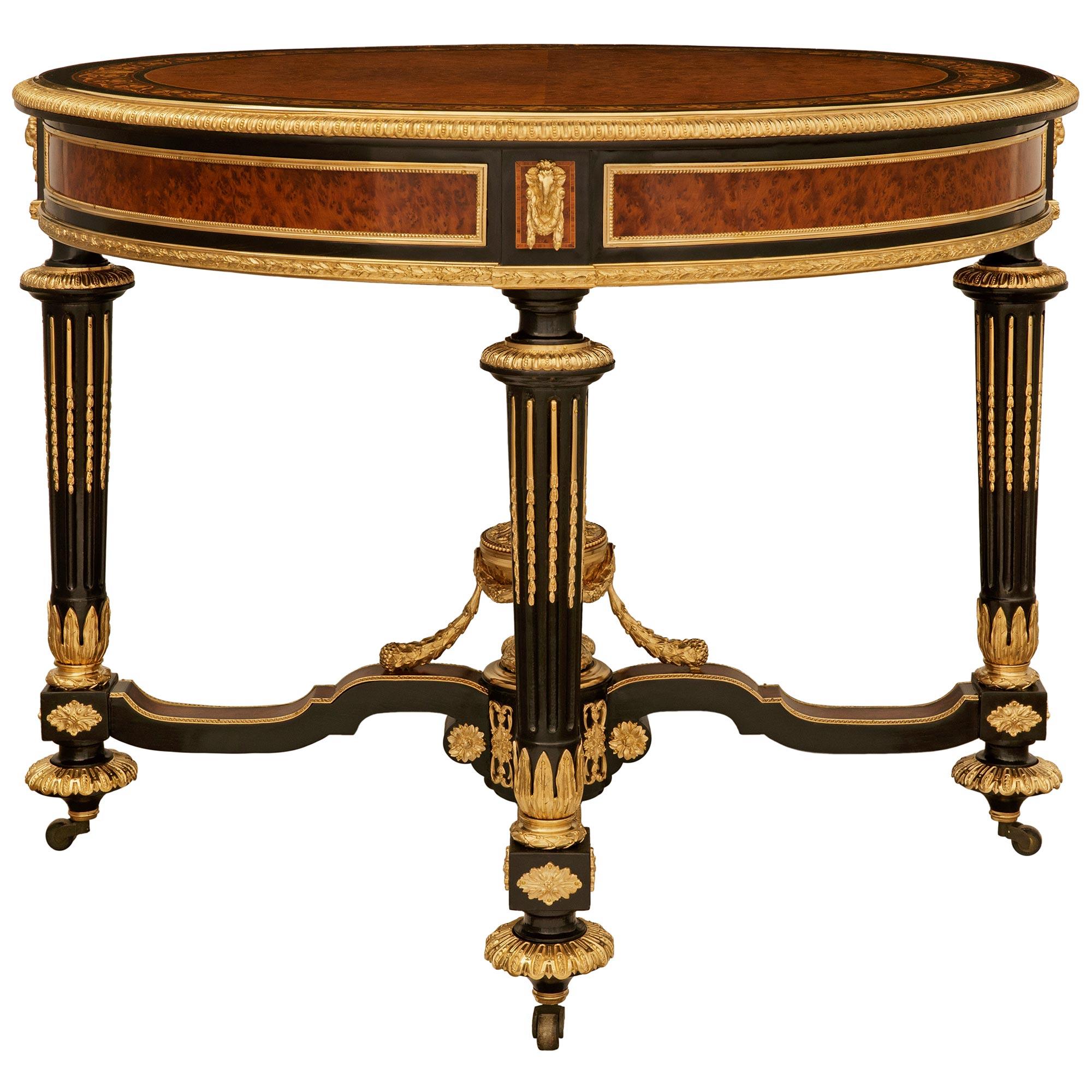 An important and most stately French 19th century Louis XVI st. Burl Walnut, ebonized Fruitwood, Maple and Ormolu center table. This exceptional table is signed on the mounts by its original maker, and is raised by four circular fluted and tapered
