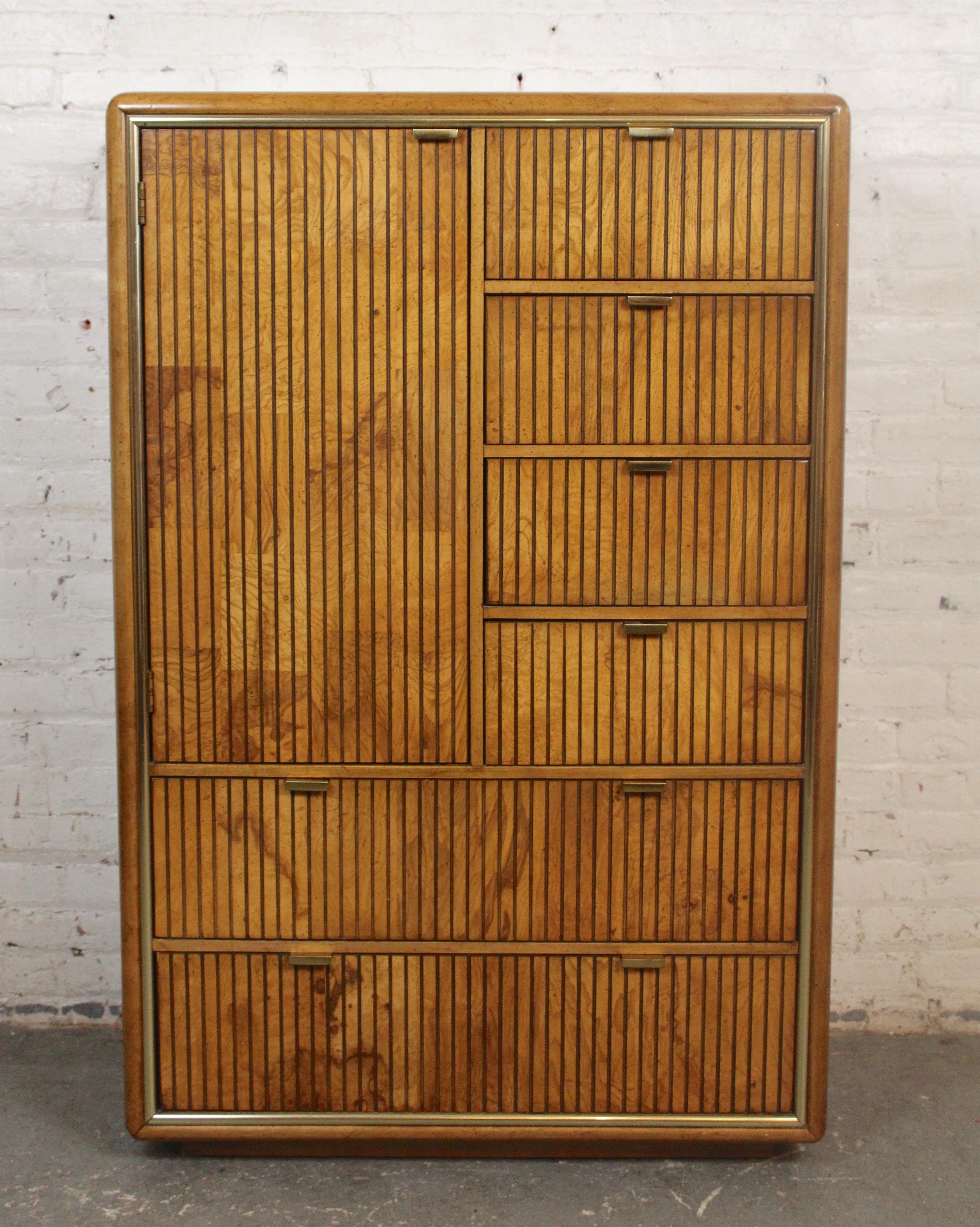 This unique highboy dresser by American of Martinsville boasts a ribbed front made of burled walnut with accenting bras hardware. Ample storage with six drawers and cabinet space with three hanging rods.
Please confirm location NY or NJ