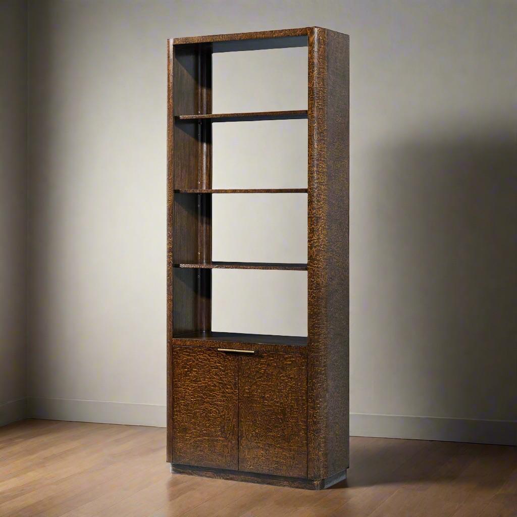 Handcrafted in a stunning Tamo ash burl veneer, this bookcase showcases the intricate and unique grain patterns of the wood, exuding luxury and timeless style. The rich Pyramid Brown finish complements the natural beauty of the burl, while the Satin