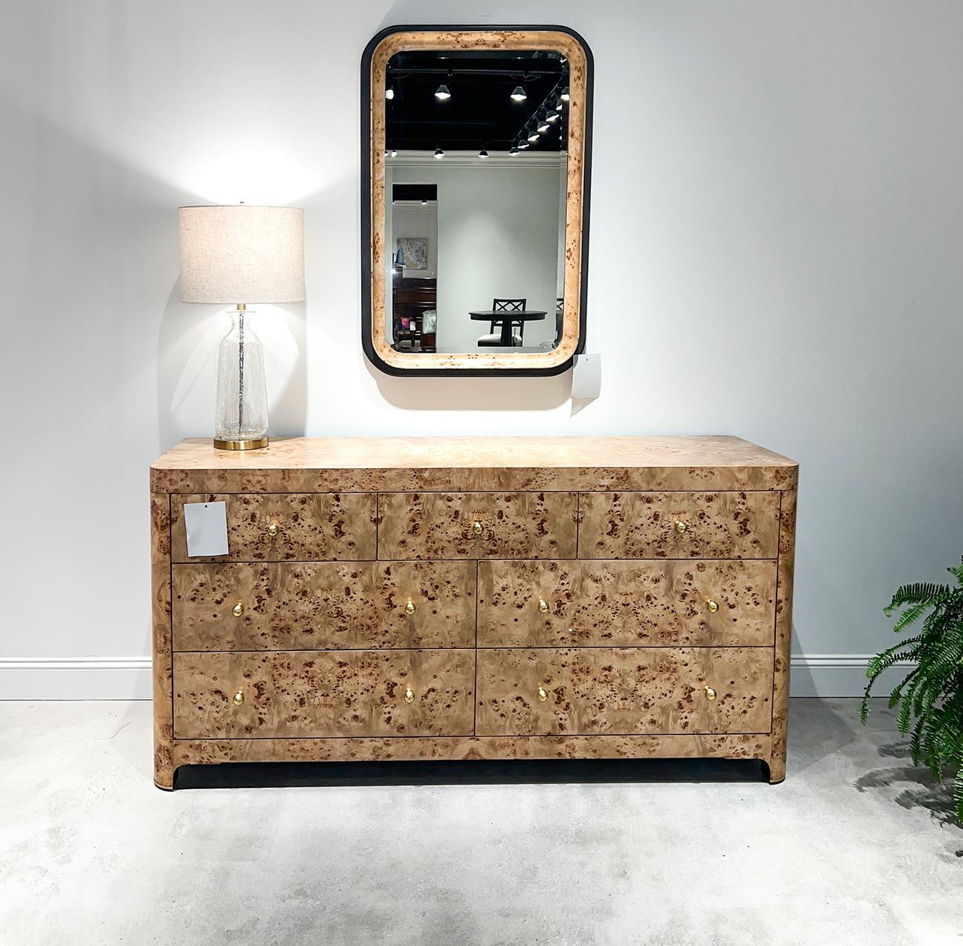 Este impresionante espejo tiene un marco de madera perfilada con un acabado pintado a mano en color carbón que complementa a la perfección el acabado transparente de la chapa de madera de Mappa Burl, mostrando las intrincadas vetas de la madera y