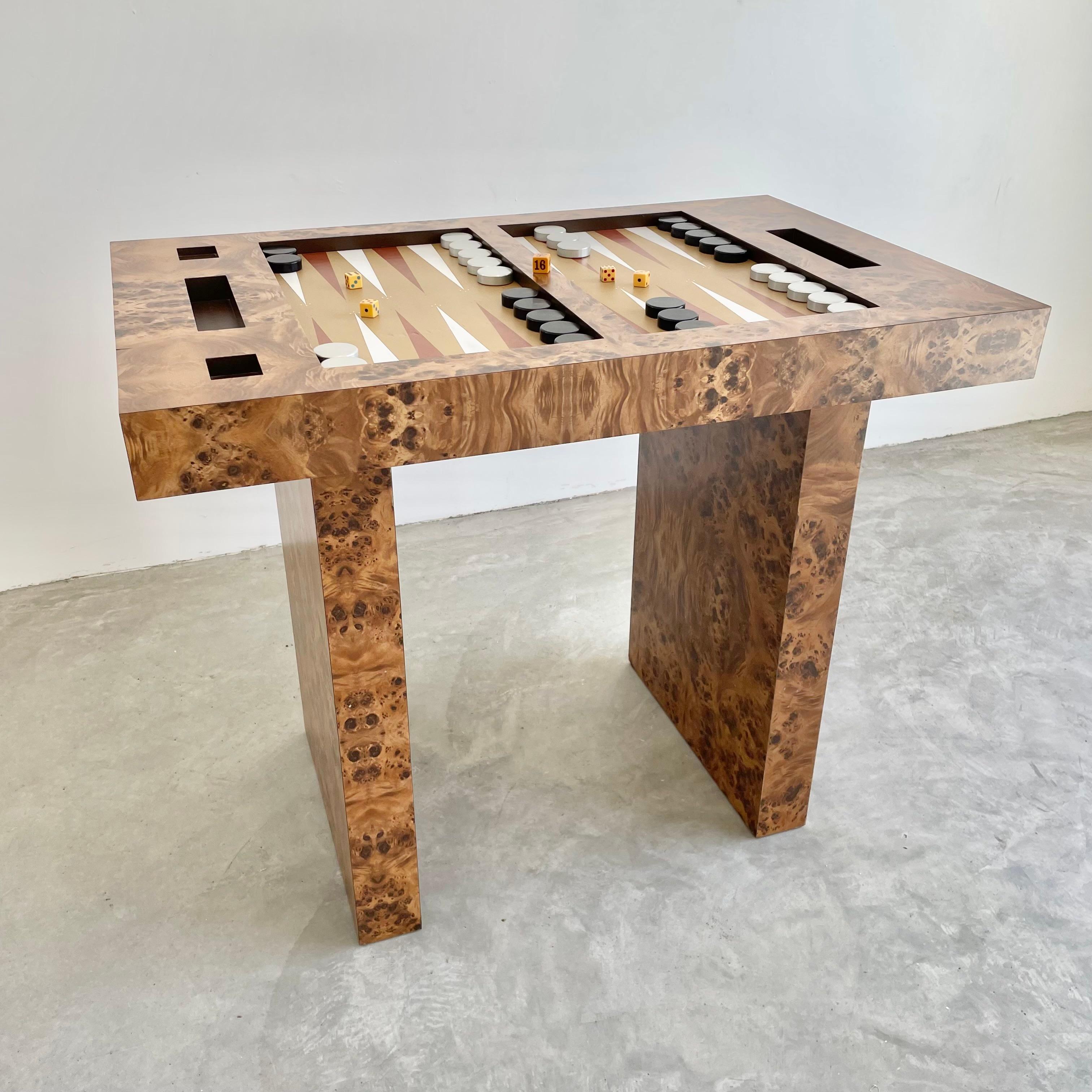 Classic backgammon table entirely wrapped in a Burl Wood venner. Playing surface is a beautiful tan leather with painted white and rust colored triangles and small polkadot details at the points. Table is supported by two thick rectangular slabs.