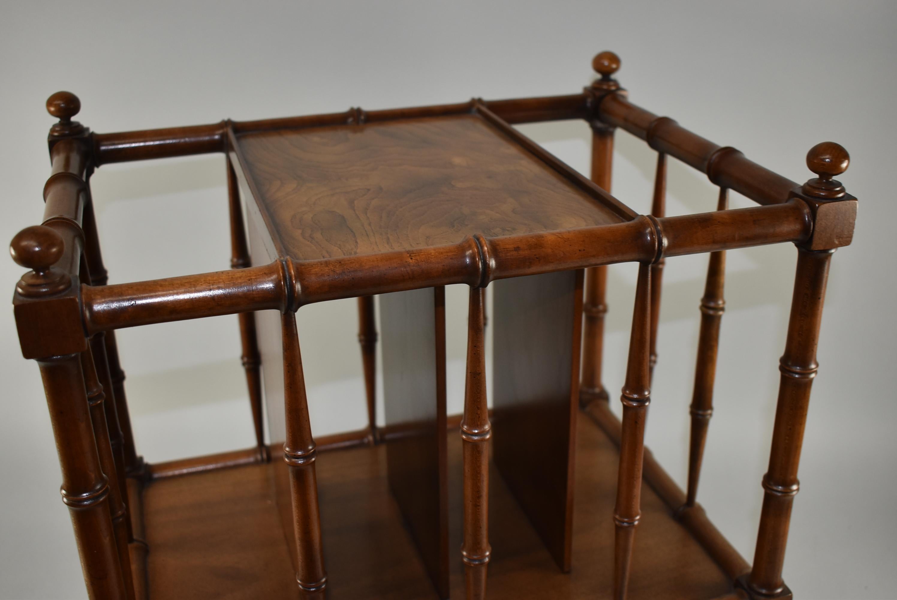 Carved hardwood in a bamboo form magazine stand by Baker Furniture. Burl wood top center panel. Brass castors. Very nice to excellent condition. Dimensions: 13