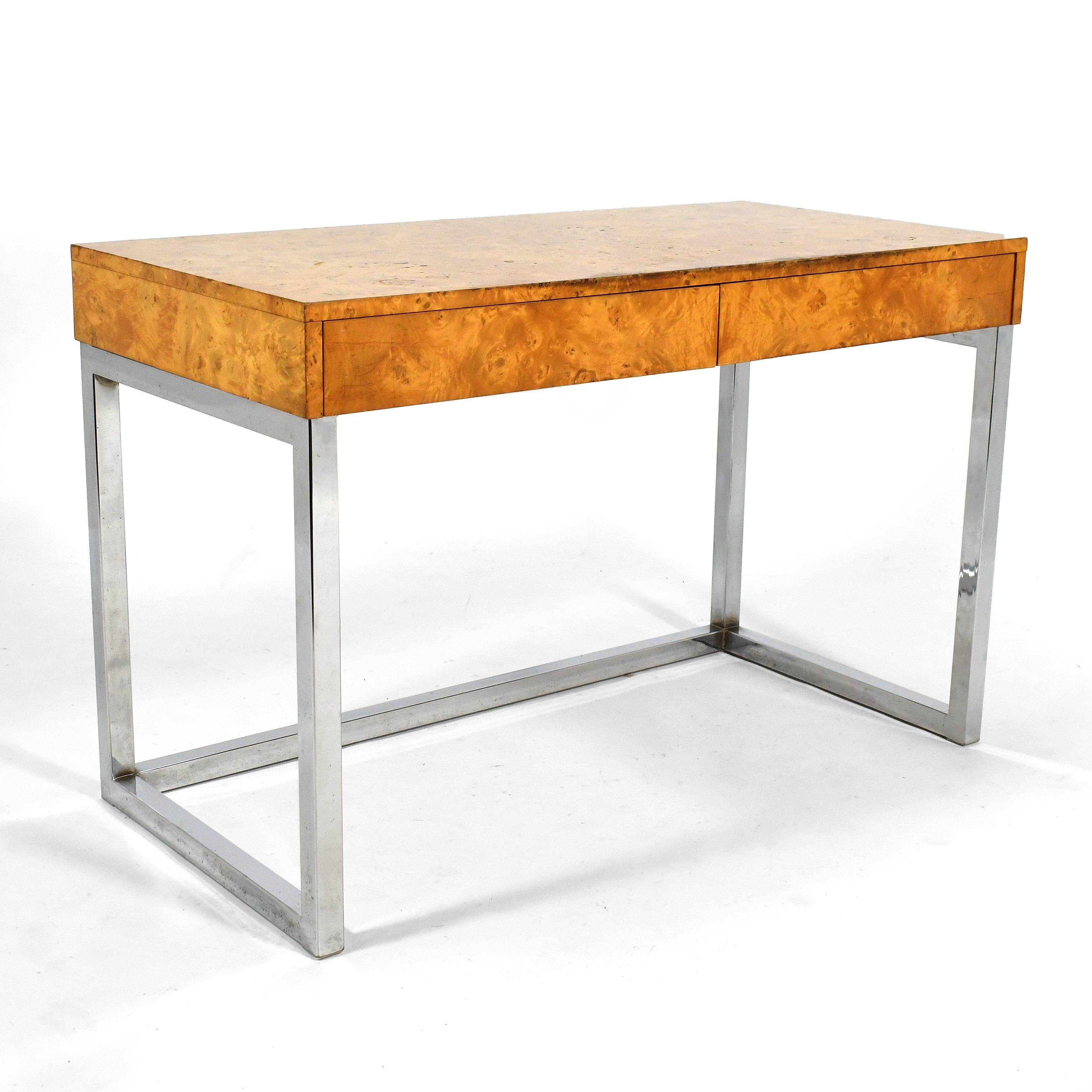 This desk in active olive burl with two shallow drawers and a chrome base clearly harkens to the designs of Milo Baughman.

Measures: 31