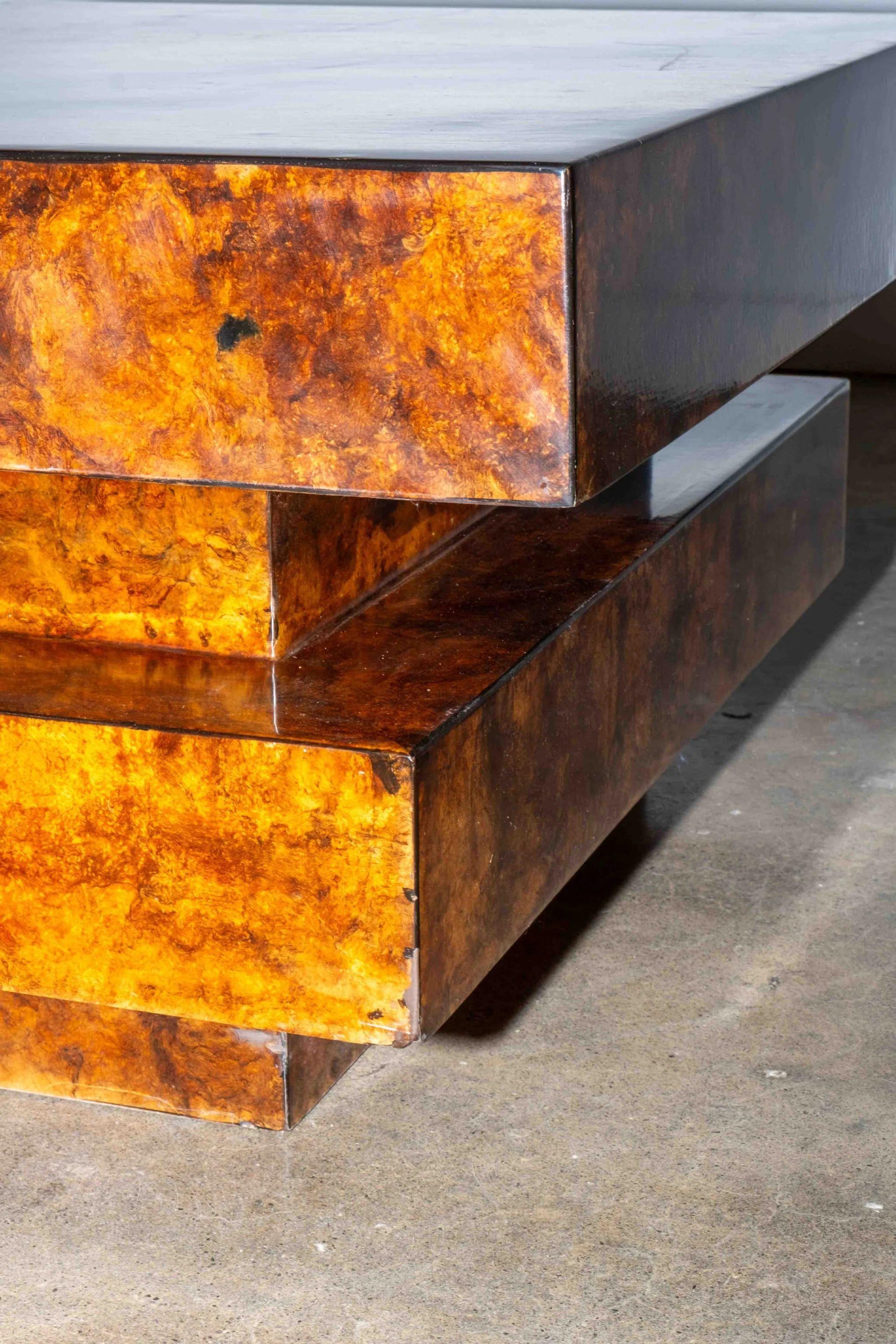 The top of the stepped deco-style burled wood coffee table opens to reveal ample storage. Believed to be by designer Aldo Tura.