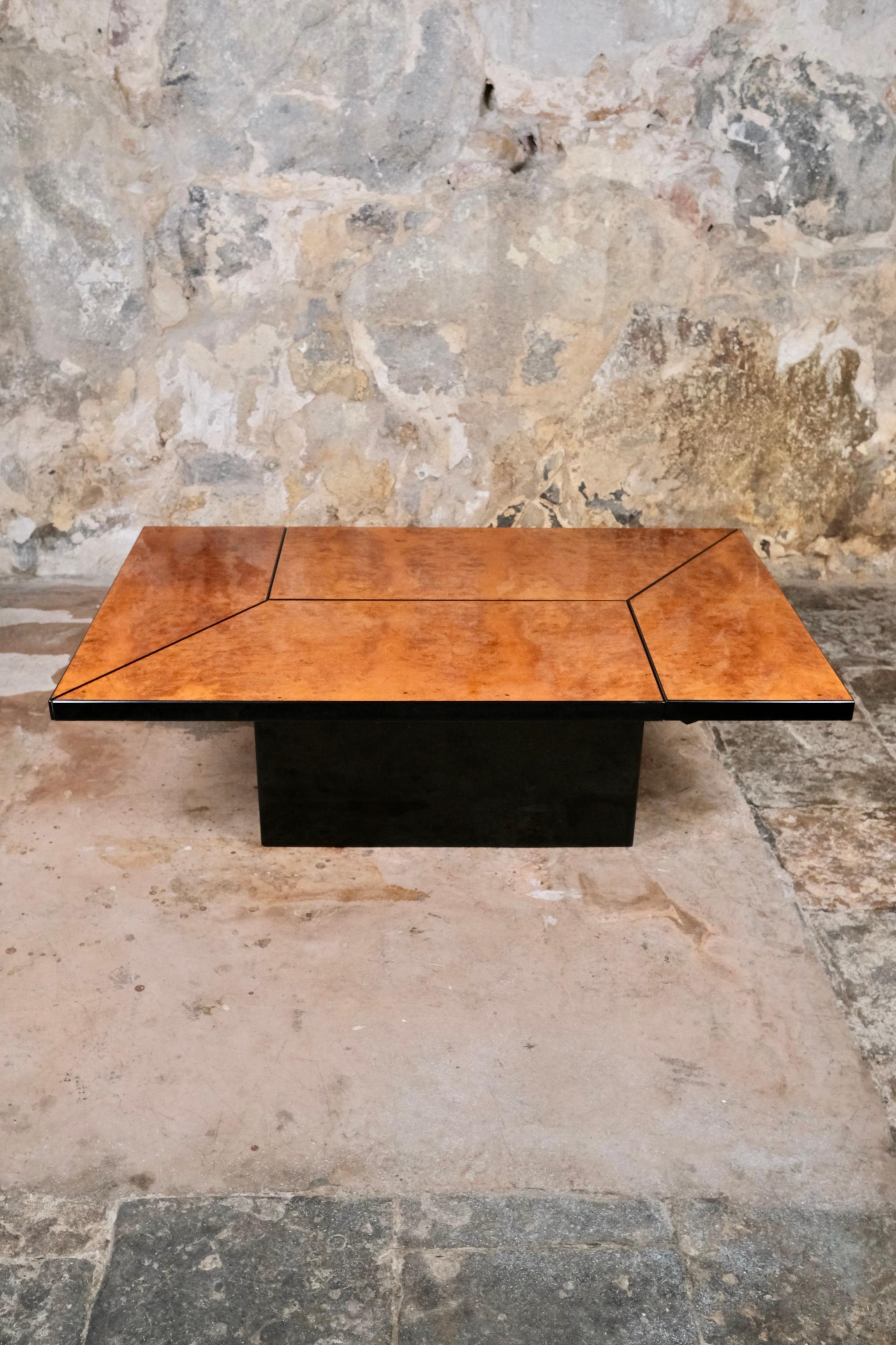 Magnifique table basse coulissante avec un bar en miroir intégral, conçue par Paul Michel pour Roche Bobois, France, dans les années 1980.
Pieds centraux en bois laqué noir, plateau coulissant en loupe d'orme, laqué.
Bar avec une tablette pour les