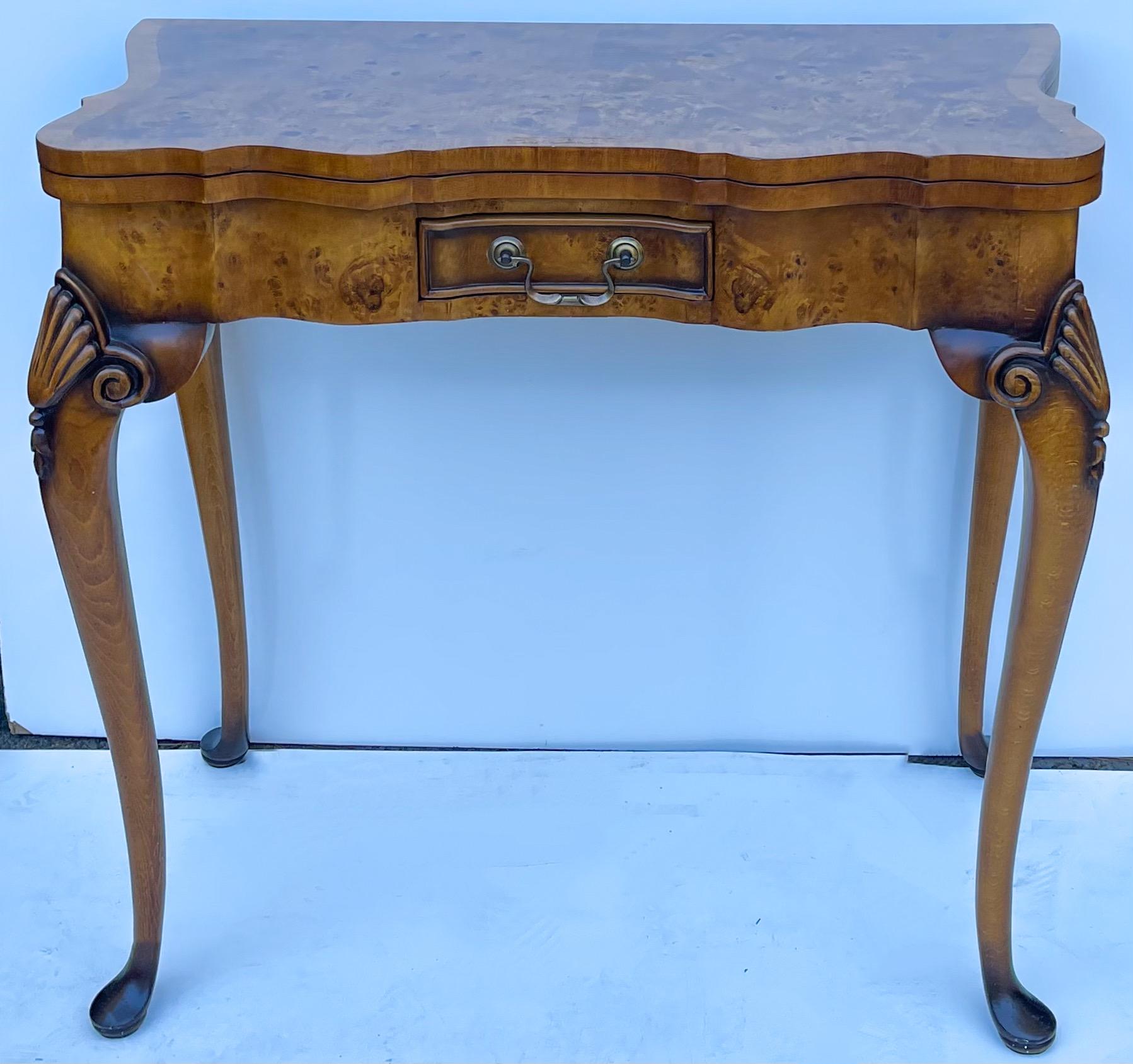 This is a handsome inlaid burl wood leather top gate leg game or console table attributed to Theodore Alexander. The tooled leather top is in very good condition. The Queen Anne style legs include one that swings to support the top. There is a