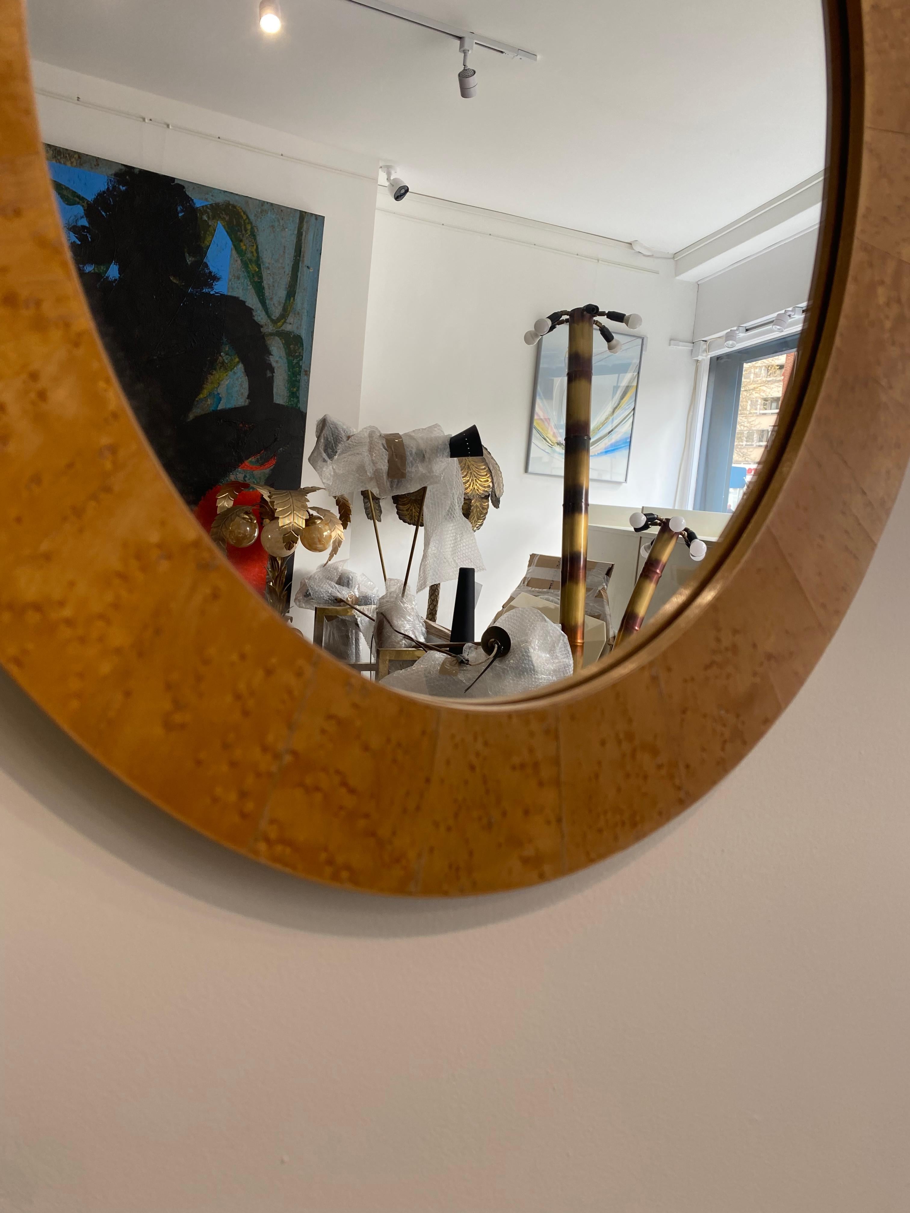 Miroir ovale dans un cadre en placage de bois de ronce assorti à un livre. Le cadre a été fabriqué au début des années 1970 et rappelle la période art déco. Le miroir lui-même est relativement récent et a été remplacé en 2010. 
Très belle pièce qui