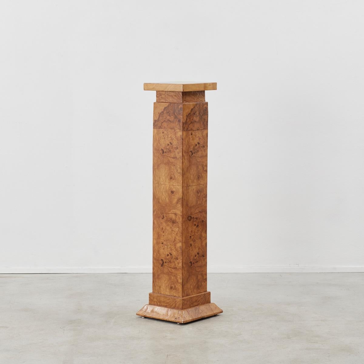 A tall plinth with a beautifully intricate burled wood surface, mimicking the natural veins of marble. The playful texture and classical geometry work together to provide an intriguing resting place for a sculpture or equally it can stand alone as