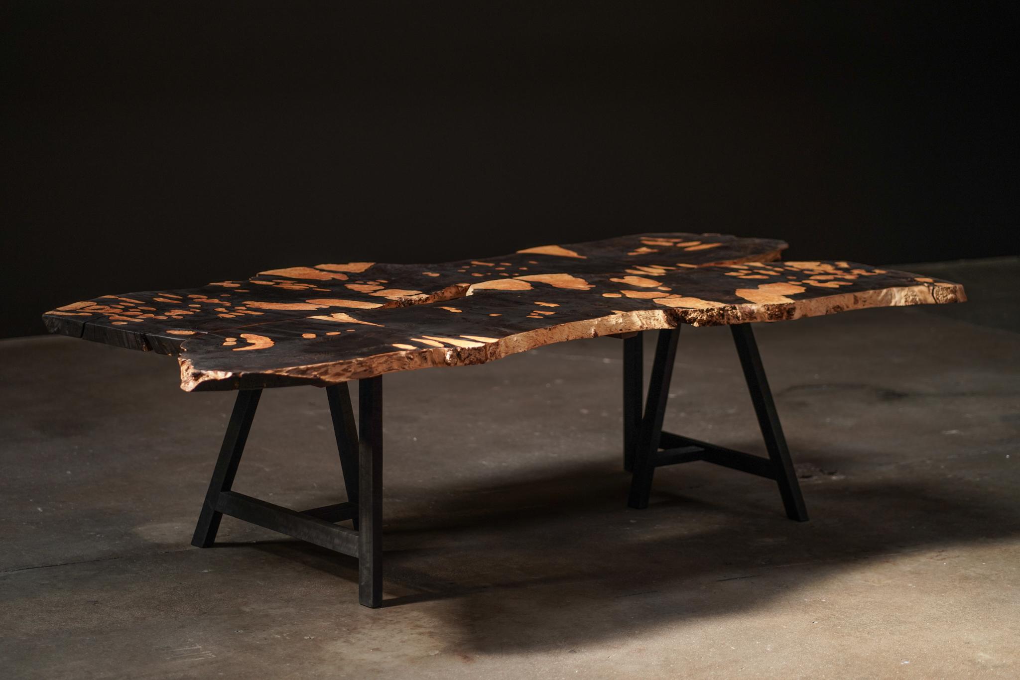 This mid-20th-century Belgian dining table features a unique wood treatment that reveals both ebonized and natural wood, creating a striking, organic pattern across the surface. Its refined silhouette brings depth and sophistication to any dining
