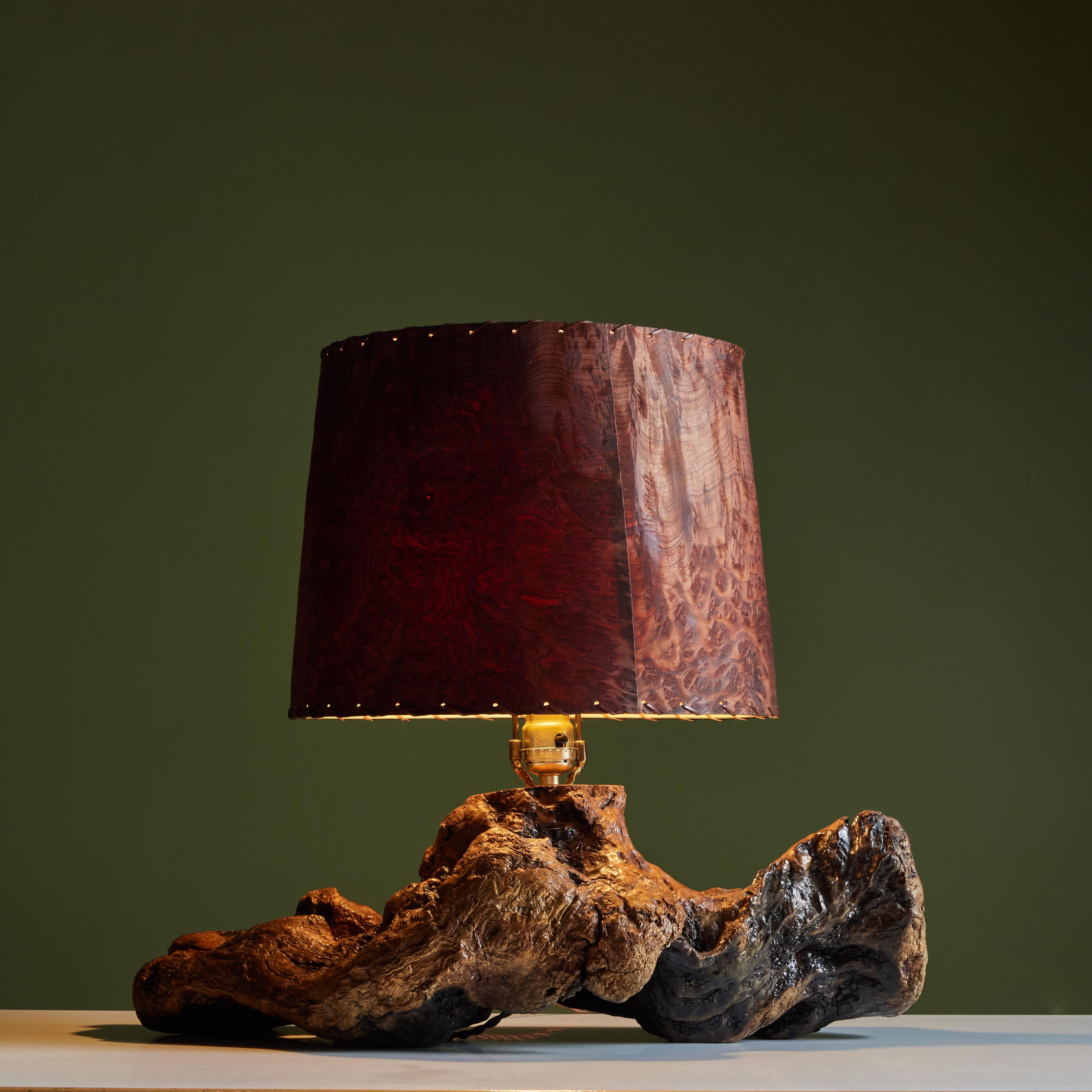 Live edge burl wood table lamp in the style George Nakashima. This studio craft lamp features a thick walnut burl base with a burl wood veneer shade and laced detail around the rim of the shade.

Dimensions
23.5