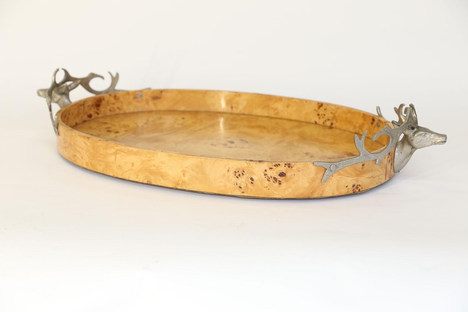 This beautiful burl wood tray is embellished with worn brass stag heads as handles. The sides of the tray are 2.5 inches high; dimensions below are for the tray at the largest points. This lovely, large tray could serve as a desk accessory or in a