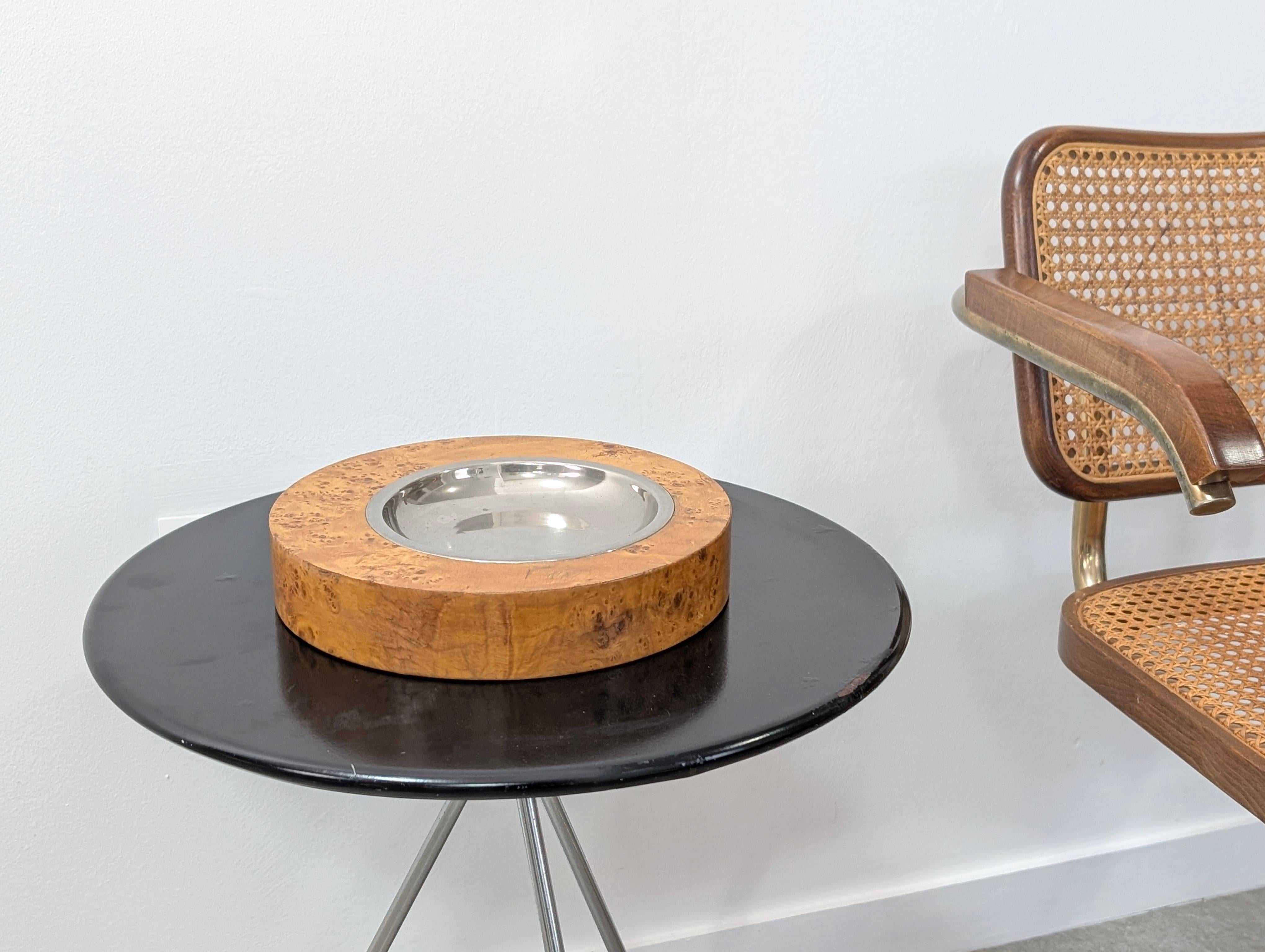 Questo affascinante accessorio Mid-Century Modern si distingue per il suo corpo spesso e rotondo, sapientemente rifinito con una spettacolare impiallacciatura in legno di radica. Il design è puramente elegante e si concentra sul mettere in evidenza