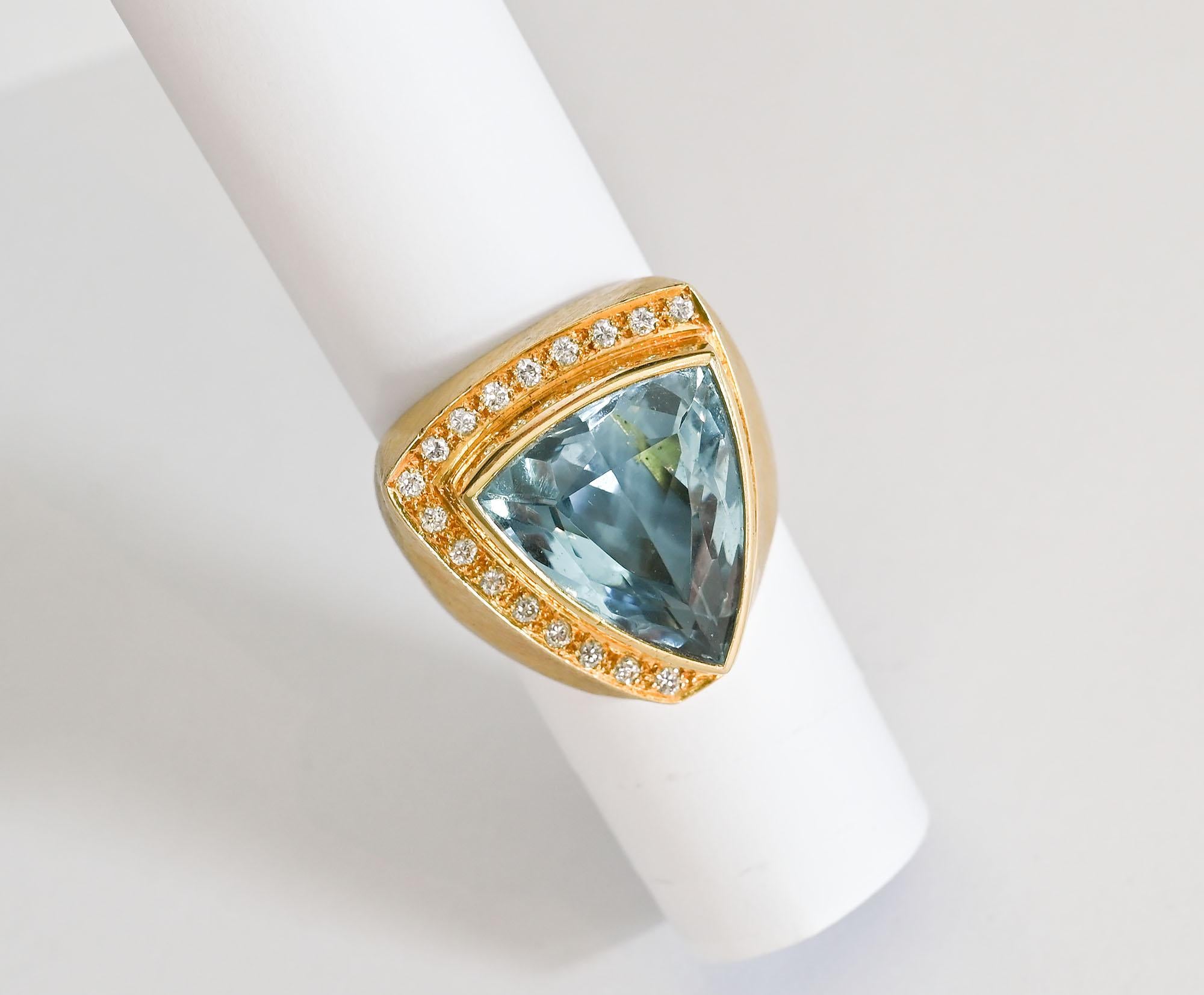 Powerfully designed blue topaz ring by Brazil's most well known jewelry designer, Roberto Burle Marx. Thie ring has a 20 carat blue topaz surrounded with diamonds on two sides. The gold has the lightly brushed finish favored by Marx. The triangular