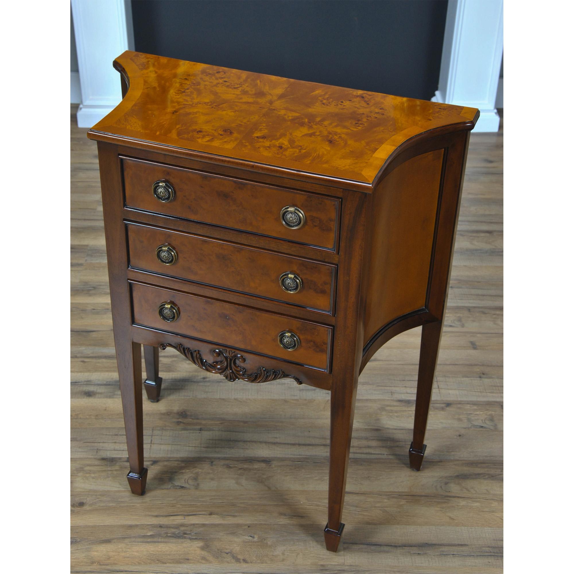 A Hepplewhite inspired Burled Commode great for use as a side table or entry way piece. The three drawers are dovetailed and feature designer style hardware, the shaped sides lend elegance and style to any room. Produced by Niagara Furniture the