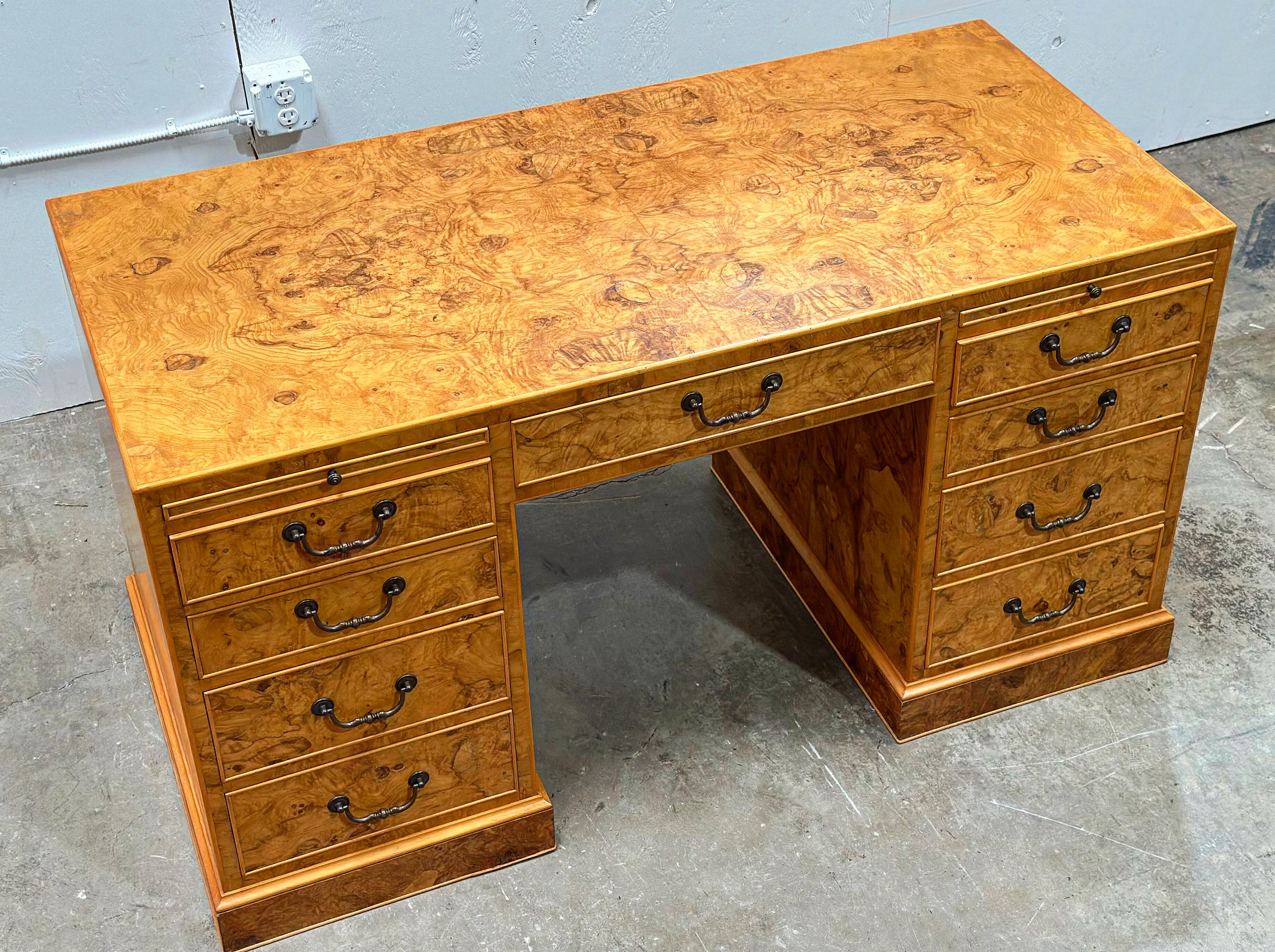Vintage burl double pedestal partner desk in olive wood with solid brass hardware, circa 1970s. Stunning organic undulating grain patterns throughout. All drawers are factory lined in a decorative finish. Four drawers and a leather lined pull out