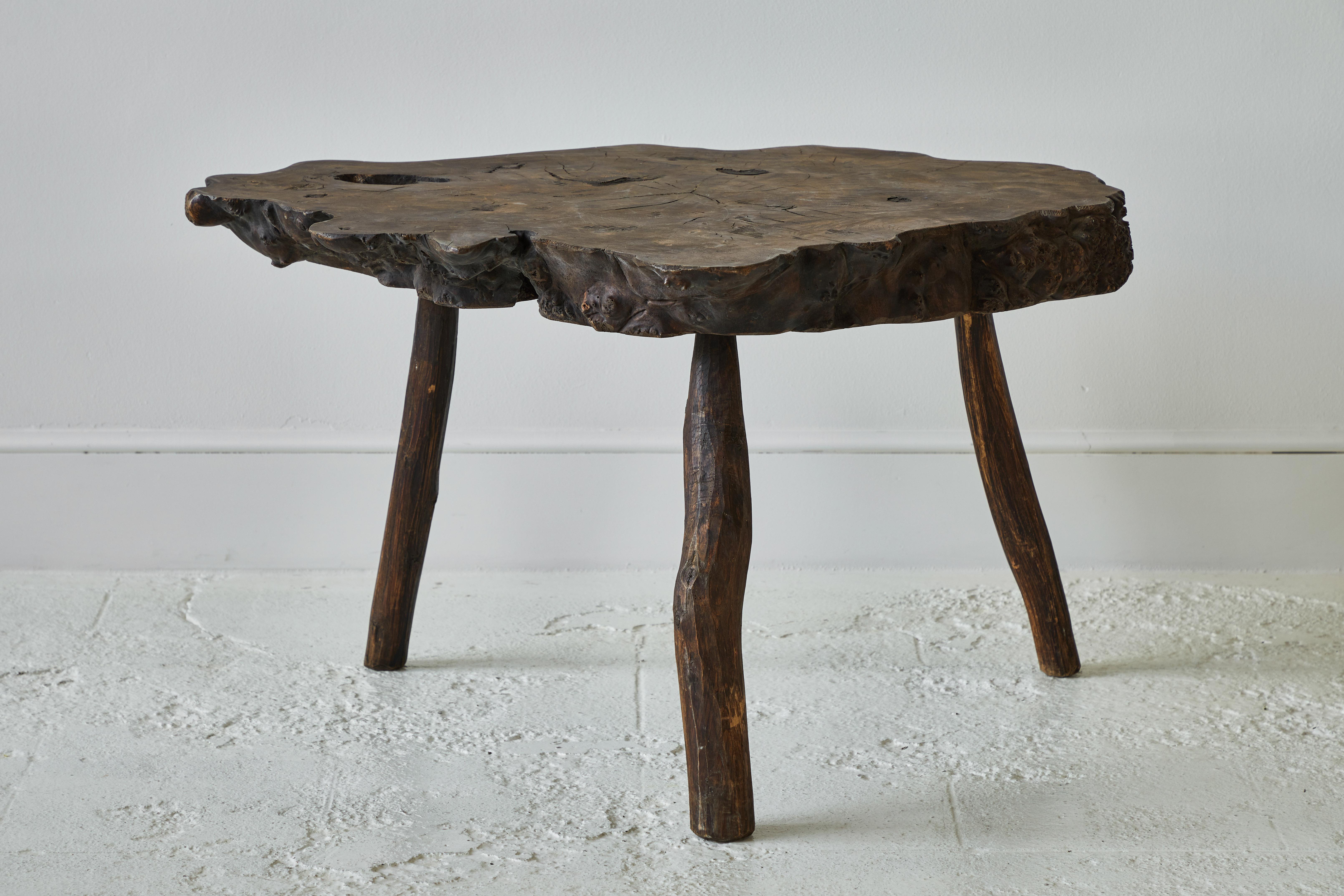 Beautiful burled and knotted three-legged rustic root table.