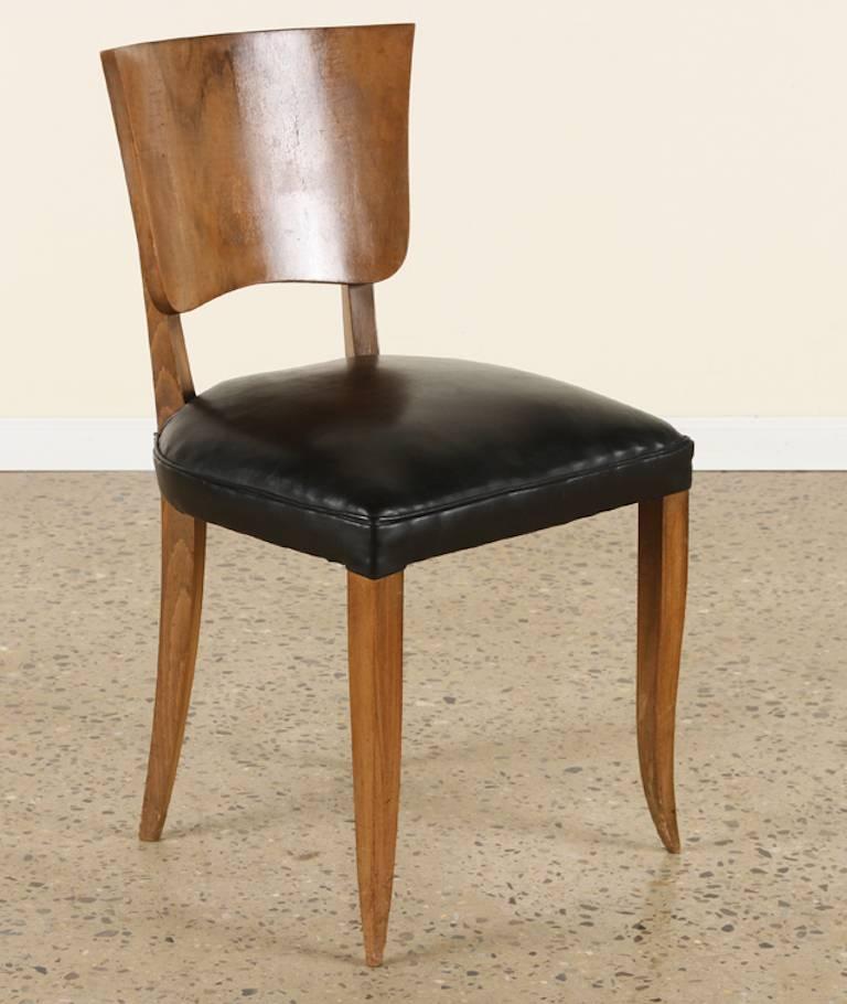 Set of six dining chairs featuring a beautiful burled walnut back, piped leather seats and striking saber shaped legs.
circa 1930s 

Measures: Seat height 18.5