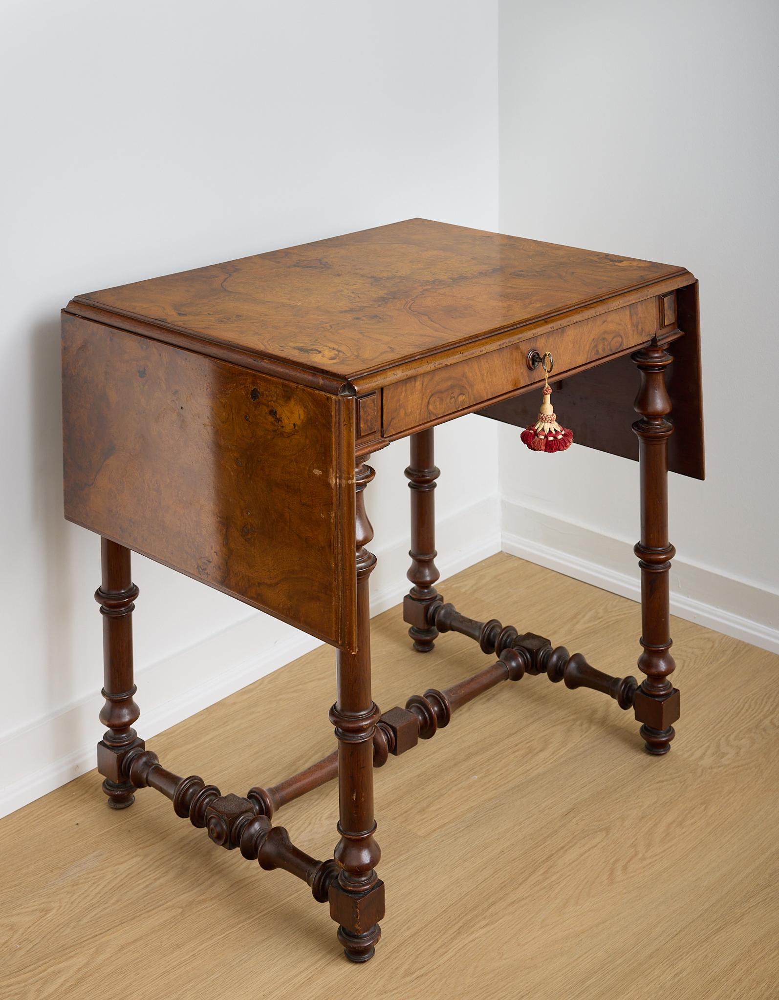 Gorgeous burled walnut console table from the 19th century, with two drop leaves and a single pull drawer, most probably made by the Herter brothers. The table is raised on turned legs with an H form stretcher.  This piece has a gorgeous patina and