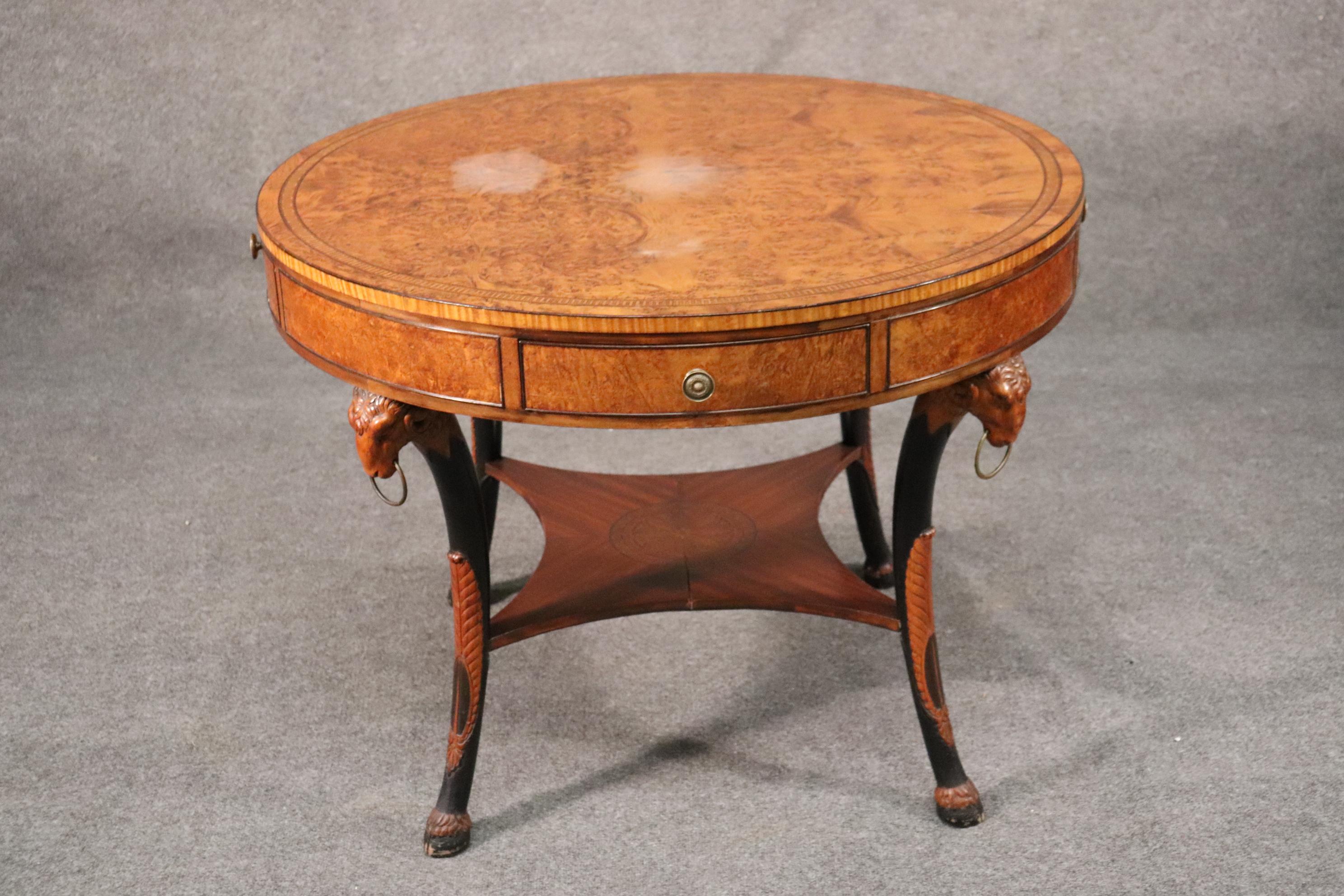 This is a beautifylly carved and designed burled walnut center table with expertly carved rams heads. The wood quality and overall quality of the table is superb. The table dates to the 1940s and does have some hazy areas on top. The table measures