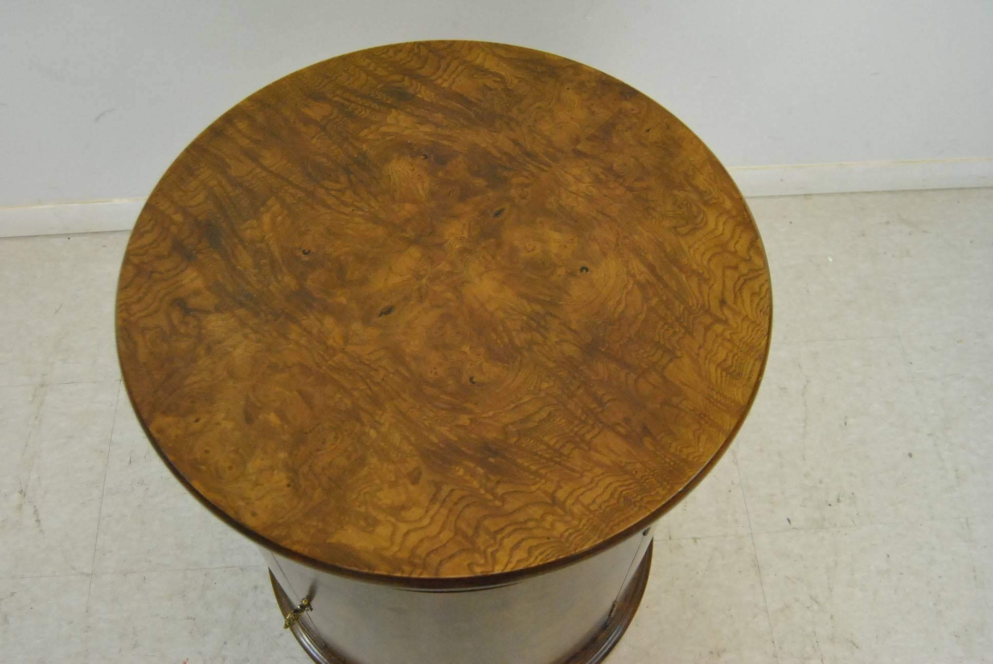 An exceptional round burled walnut pedestal table by Henredon. This beautiful piece features a single door and an adjustable shelf. Very good condition with the original finish. Beautiful and designed for daily use. Dimensions: 21