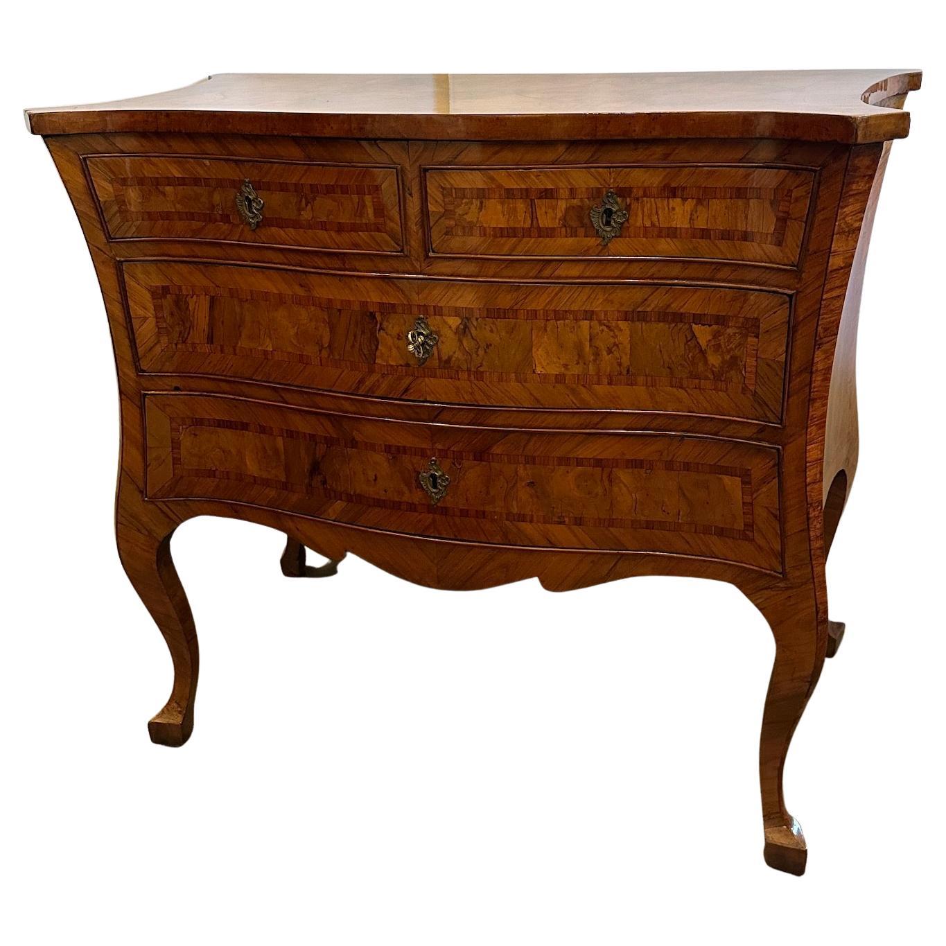 An elegant burled walnut veneered, inlaid, serpentine shaped commode.  Bronze hardware with traces of gilding.  4 drawers.  