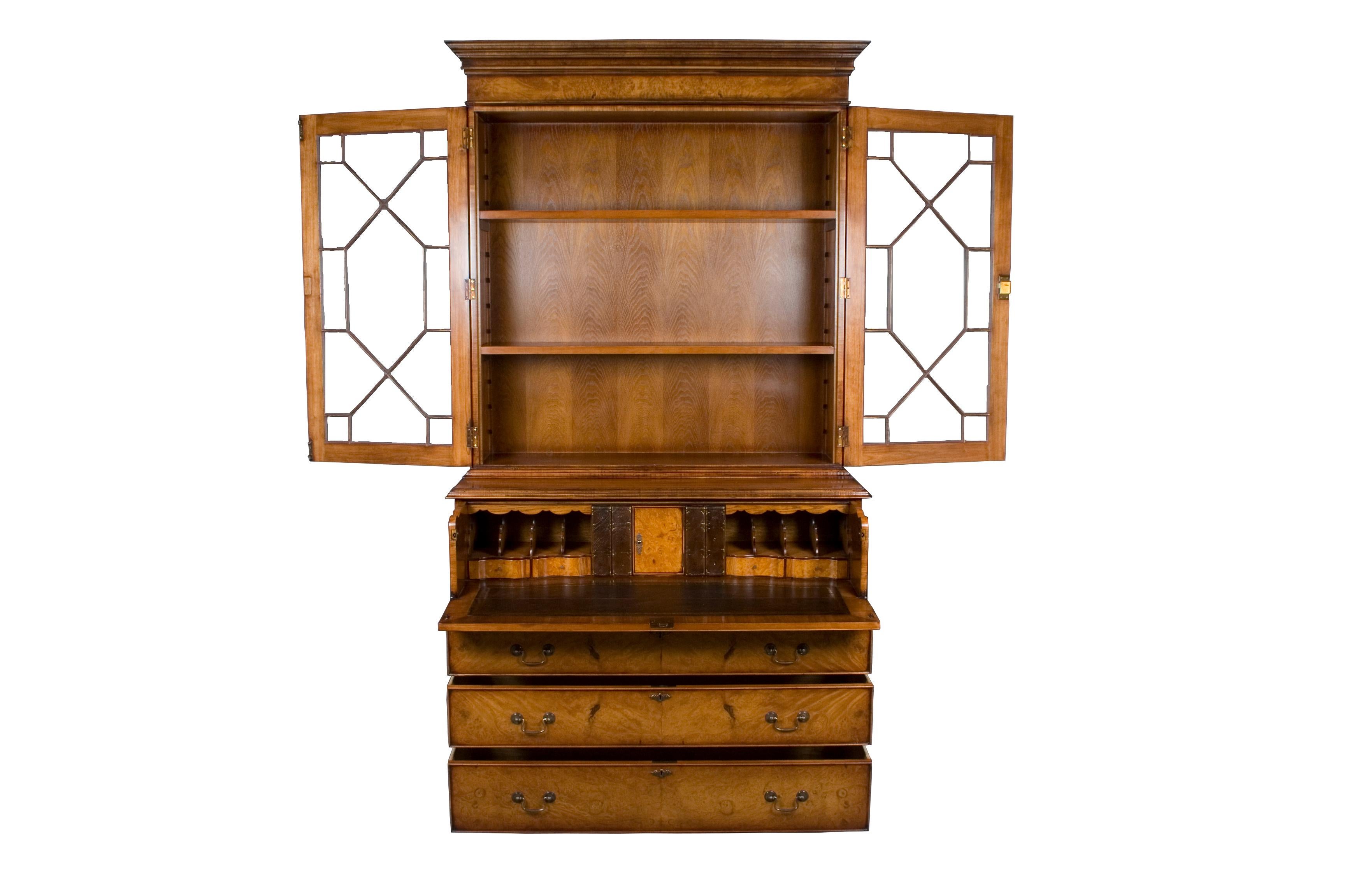 This burl walnut secretary bookcase, also known as a bureau desk, is handmade in England as a Georgian Period reproduction. This is a new item. Every aspect of this English-made secretary desk, from the techniques used to the materials themselves,