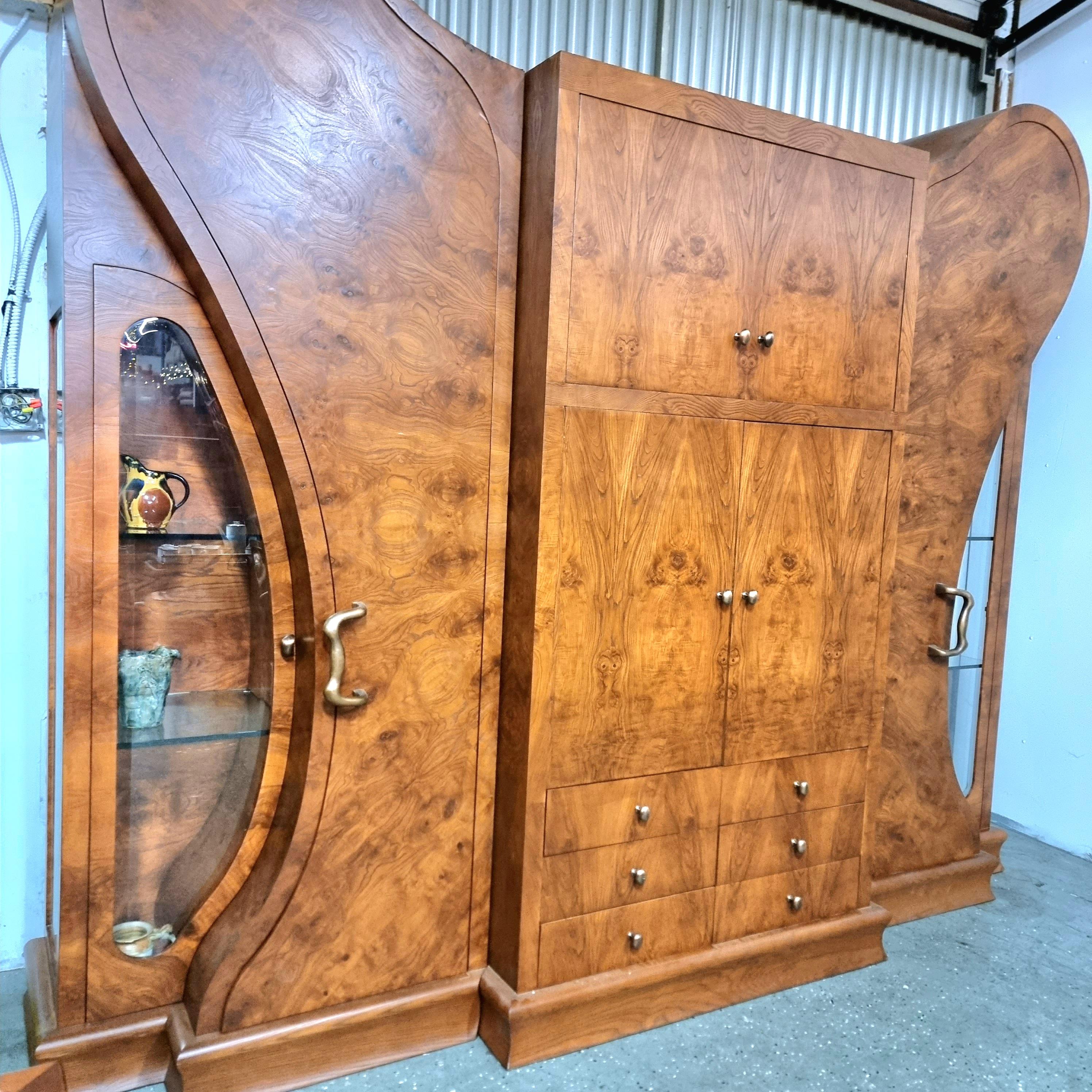 
A unique, one of a kind, original burl wood wall unit/ entertainment center. This unique piece is of the highest quality. It features gorgeous burl wood doors, 2 glass side panels that display with 2 adjustable glass shelves, and in the center 2