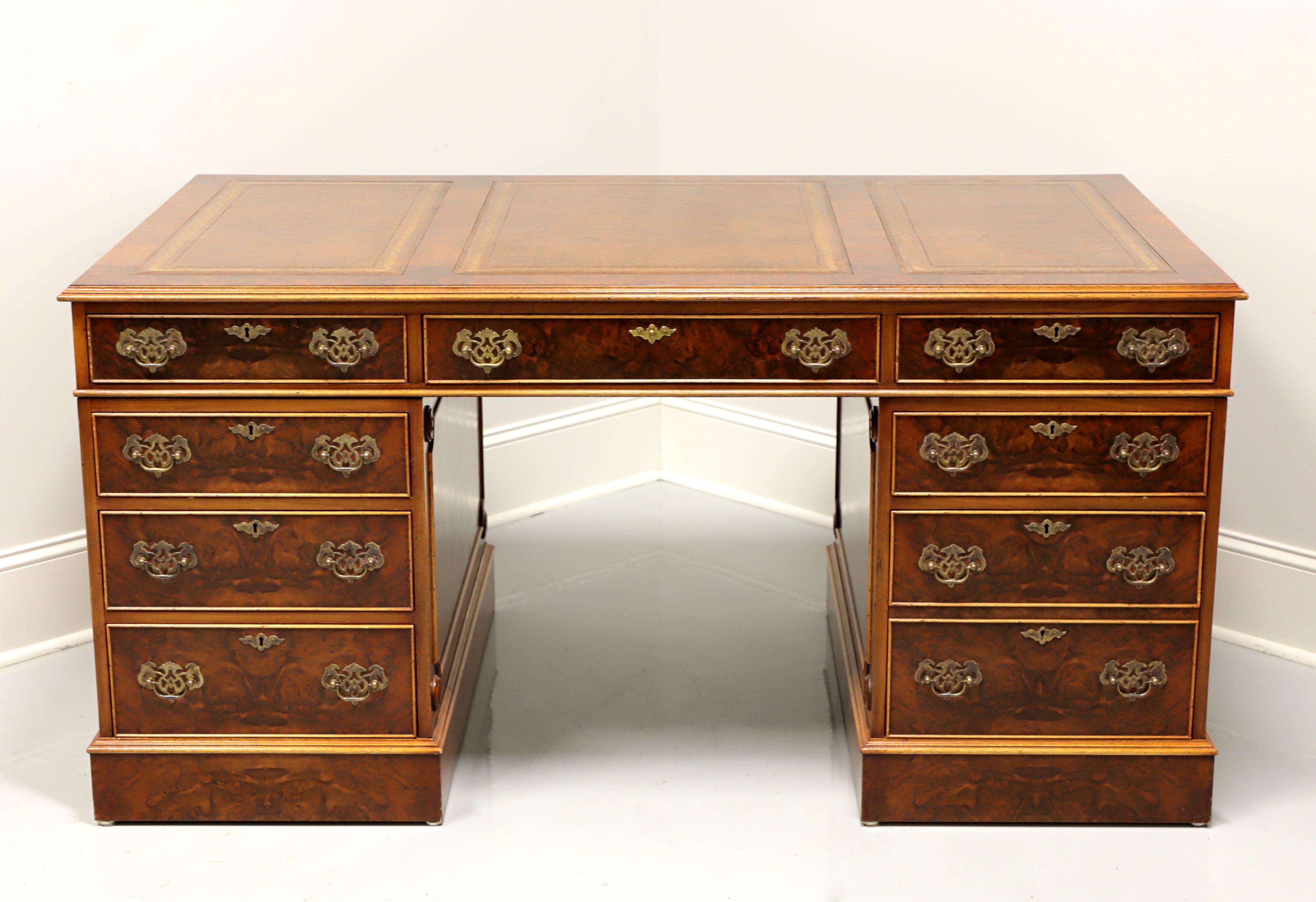 A Traditional style double pedestal executive desk, unbranded. Burlwood with inlaid mahogany, tooled leather top and brass hardware. The user side of the desk features eight lockable drawers of dovetail construction, including one longer center