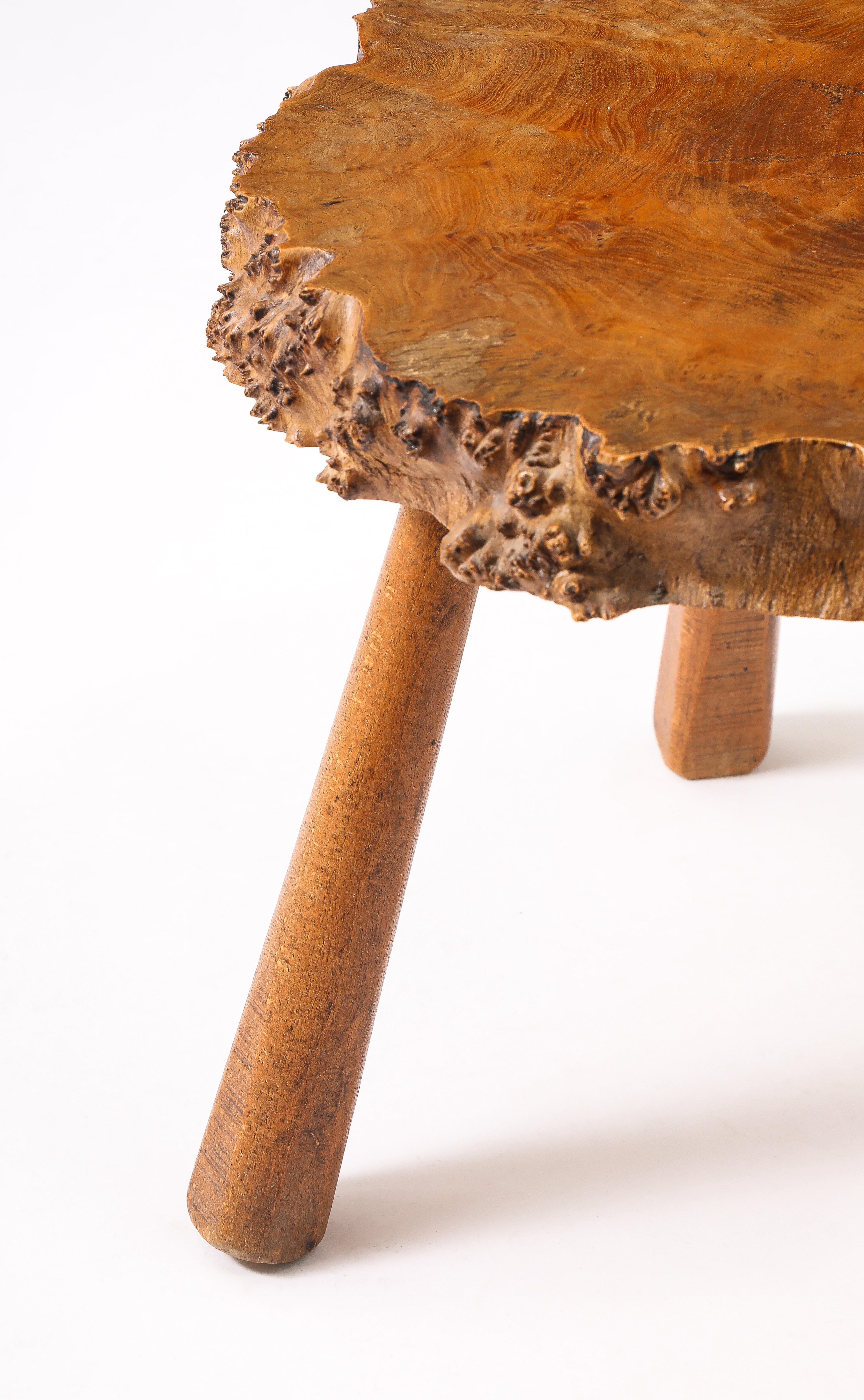 Live edge burl wood side table on tripod tapered legs.