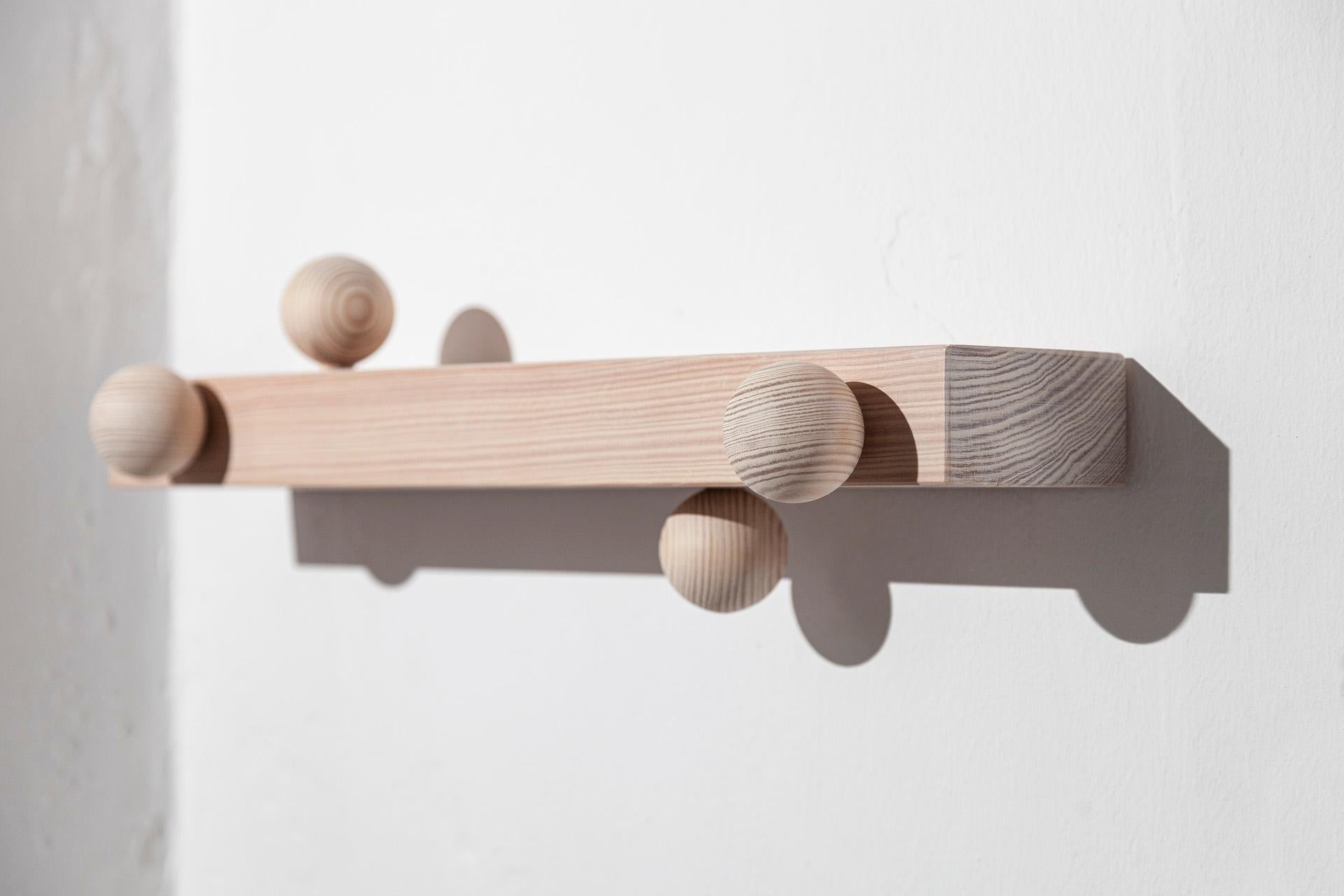Burly is the name of this collection of solid pine wood coat hangers. Designed by João Xará and handmade in Portugal, this coat hanger has a set of spheres - made with the help of an artisan specialized in turned wood - serving as hangers, in