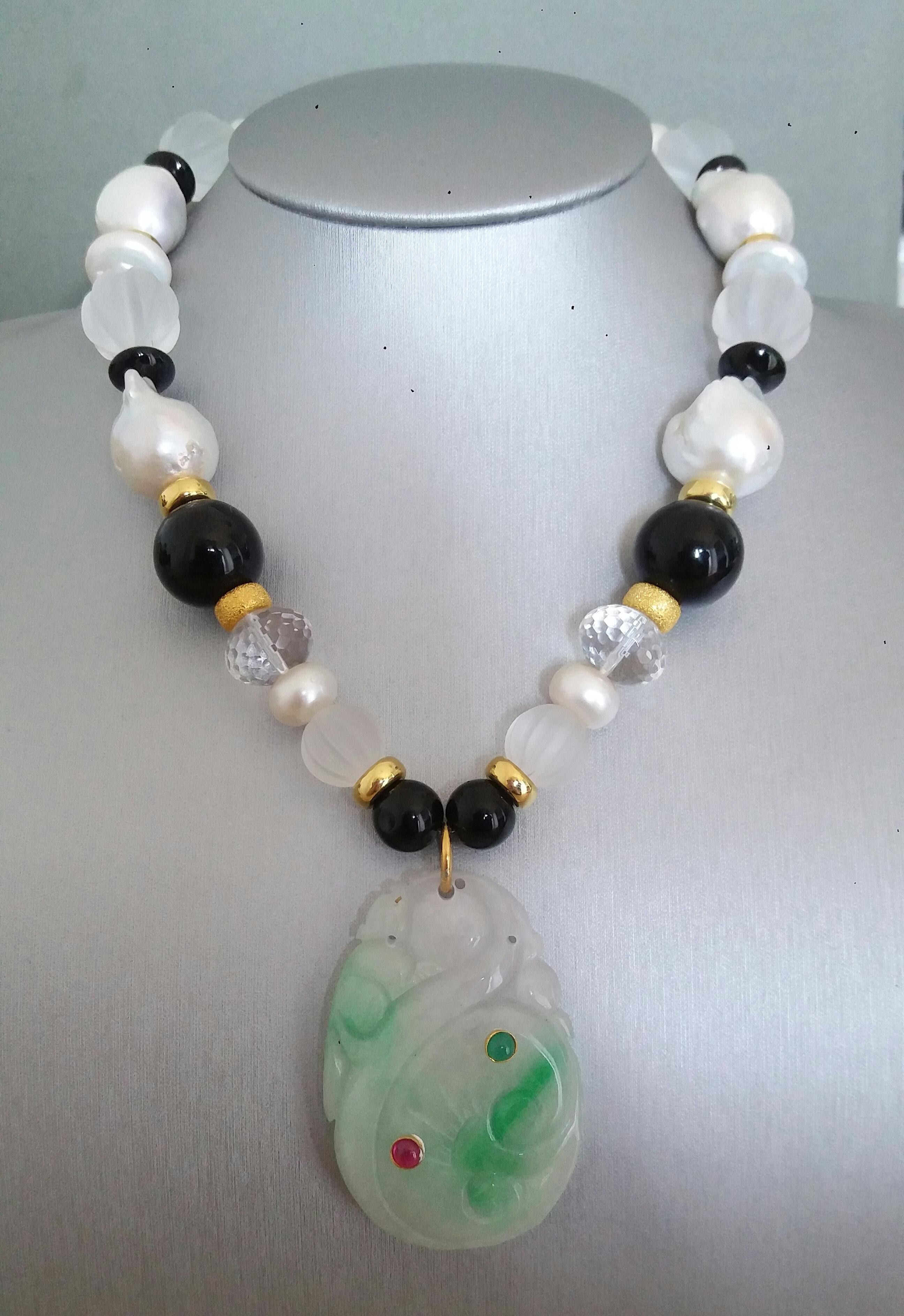 Unique and classic Necklace composed of big size Baroque Pearls, Faceted Quartz, Black Onyx 16 mm diameter, 14 kt Yellow Gold elements, from which hangs a pendant of engraved Green Burma Jade 35x50 mm with 2 small round cabochons of ruby and emerald