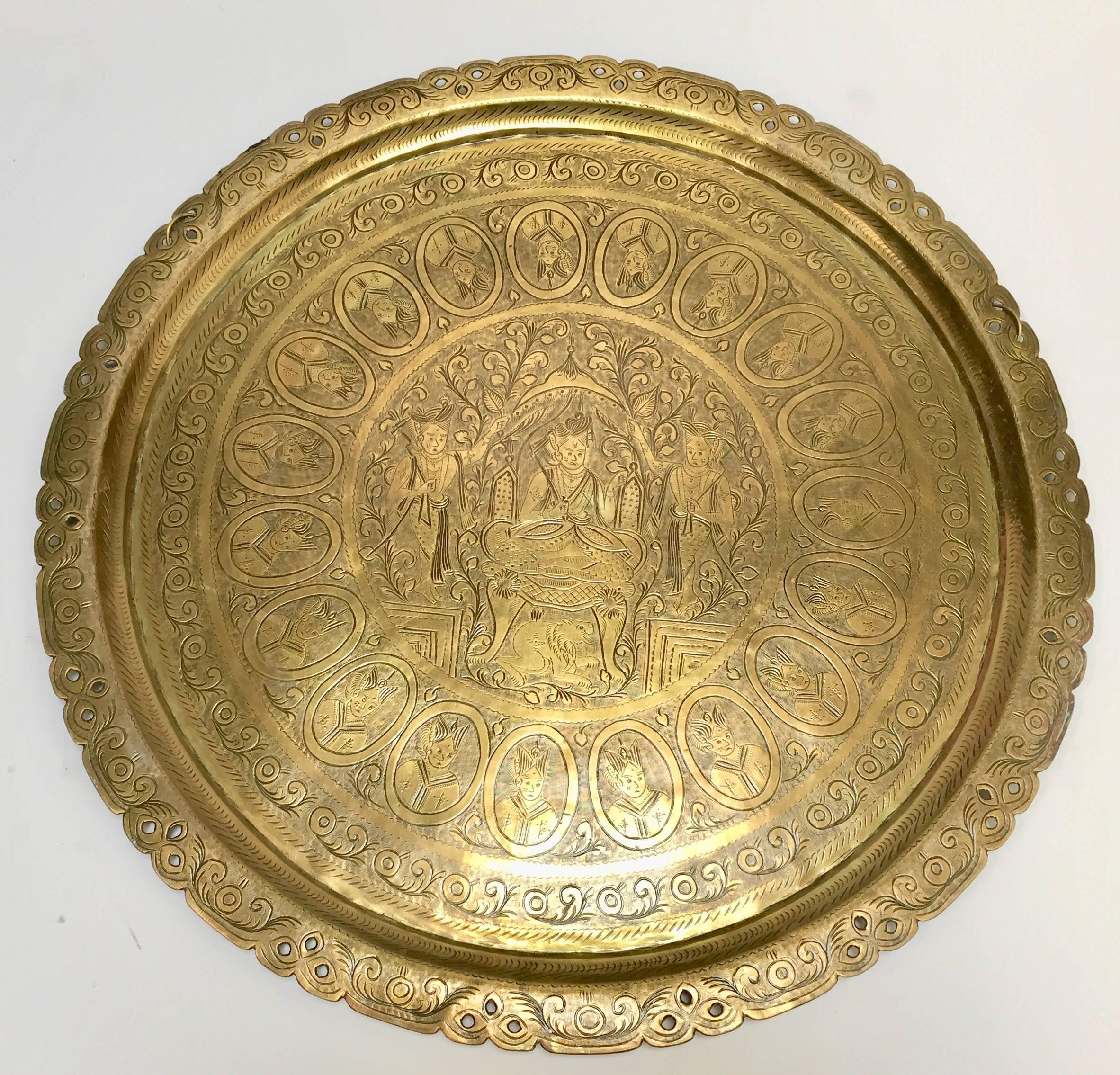 Rare find, Asian brass round tray hand chased with in Mameluke style.
Engraved scenes with a King on his throne and disciples depicting a story of a royal court life, and the same figure of a king all around.
Gold polished varnished brass,