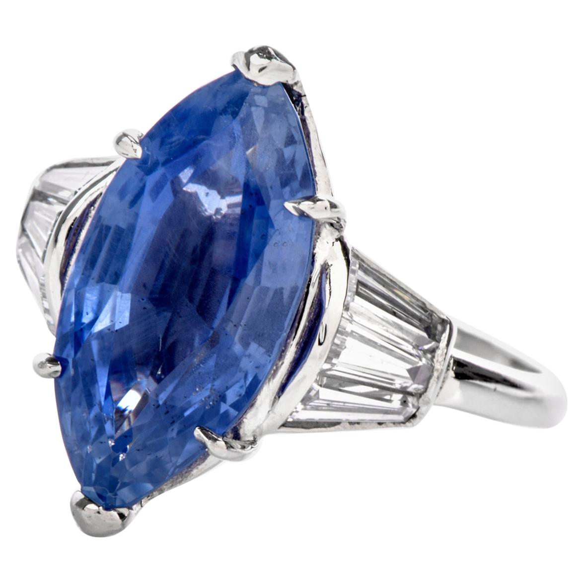 This lovely marquise design is crafted in solid Platinum. Centered with a dazzling 6.58-carat natural no-heat Burma Sapphire, prong set. It is adorned to the sides with 6 genuine tapered baguette cut Diamonds of an approximate carat weight of 0.75