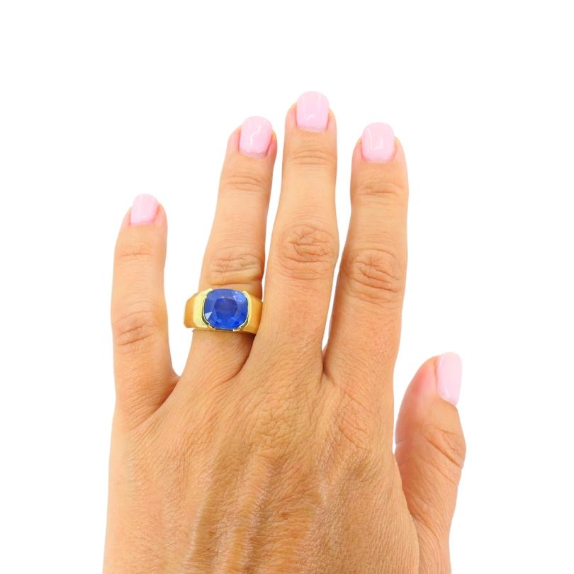 
This exquisite ring features a stunning natural sapphire of Burmese origin, renowned for its rich, vibrant blue hue. The sapphire, weighing approximately 6.99 carats, is cut into a cushion shape with a brilliant cut crown and step cut pavilion,