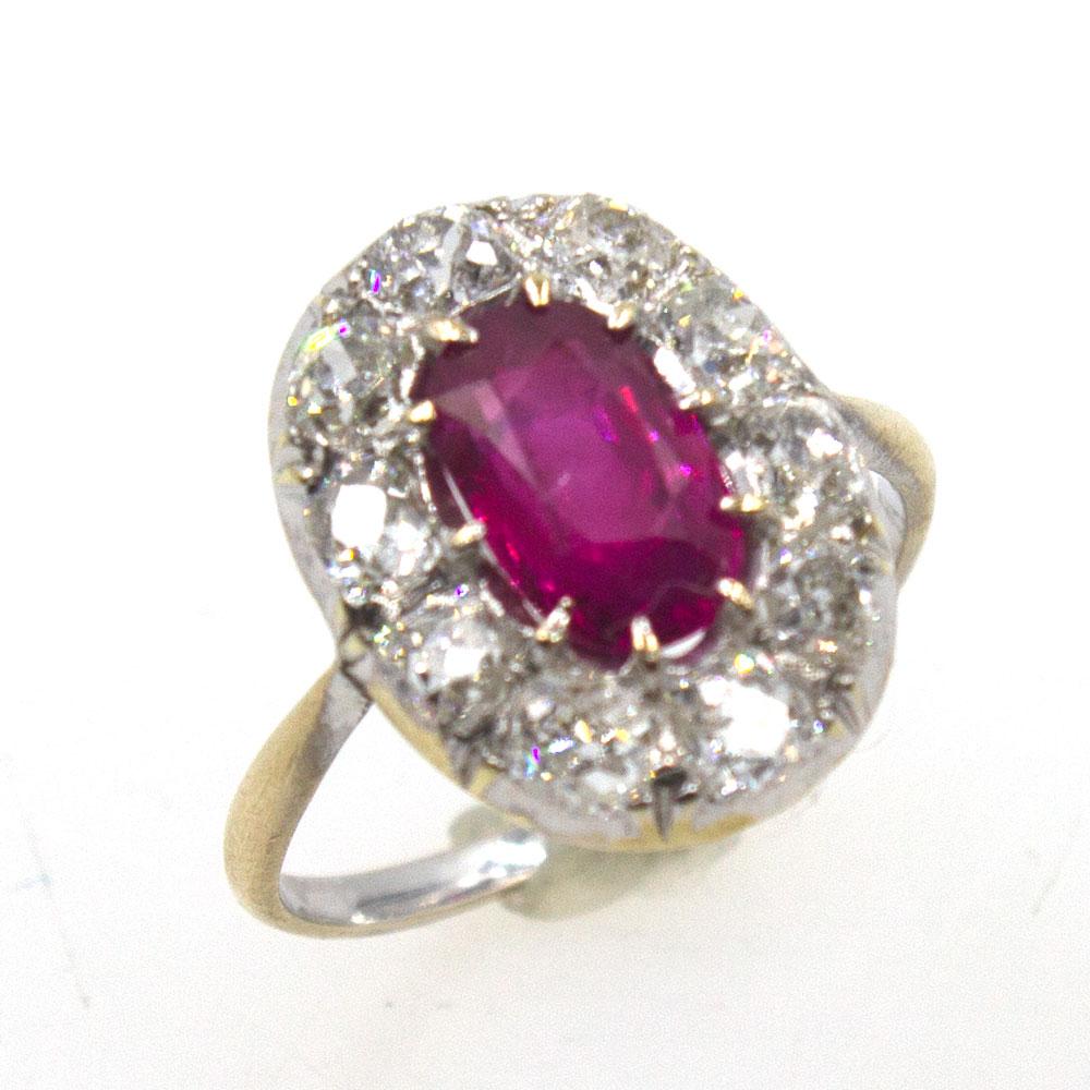 Gorgeous Burma Ruby and Diamond Antique Ring. The yellow and white 14 karat gold mounting features 10 near colorless Old Mine Cut diamonds that equal approximately 1.50 carat total weight. The diamonds surround a 9.57 x 6.18 x 3.97 mm Natural Burma