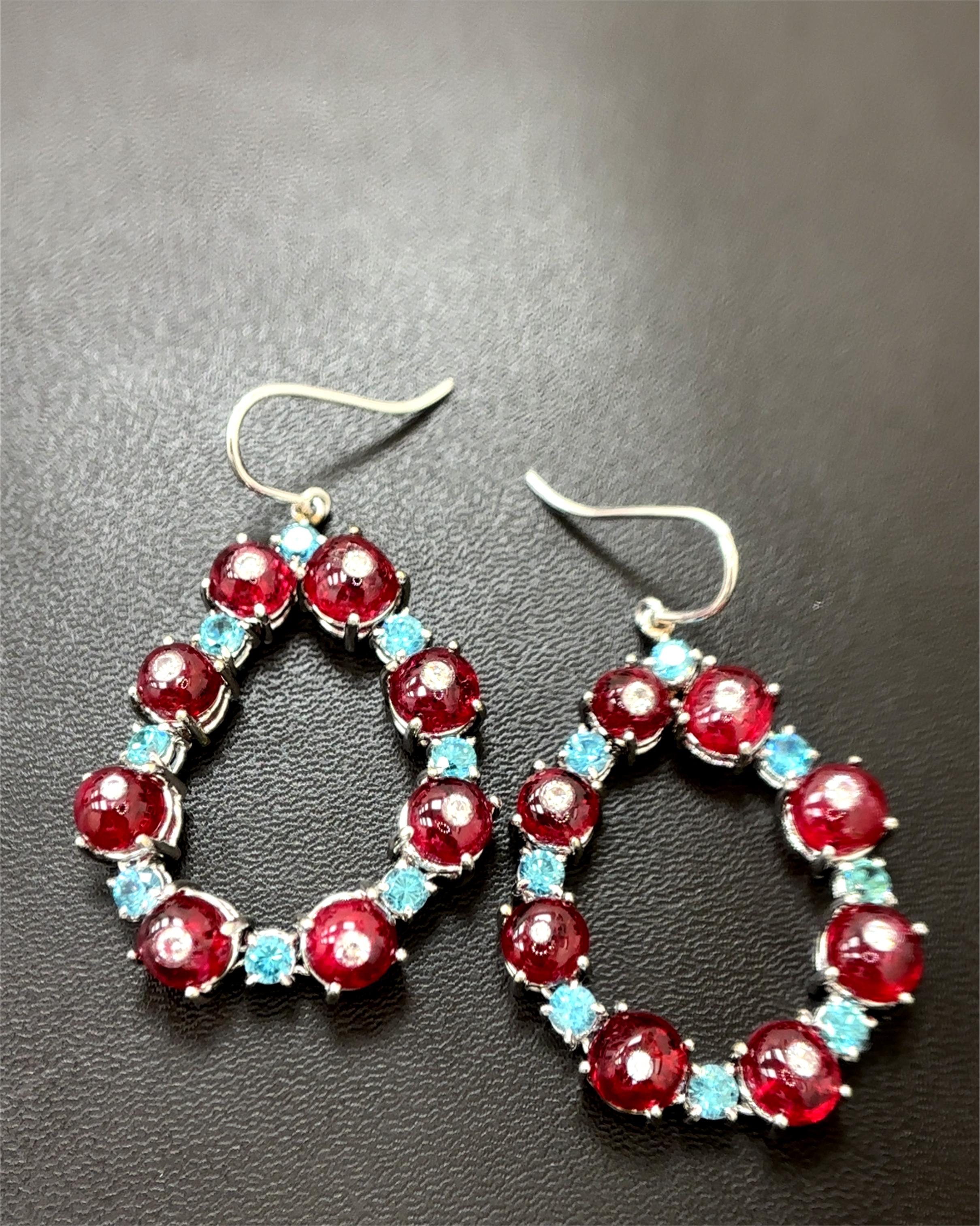 Indulge in the epitome of luxury with these breathtaking earrings, meticulously crafted to captivate and enchant. Mounted in the finest 18k white gold, this masterpiece showcases an elegant teardrop design adorned with the rarest and most vibrant