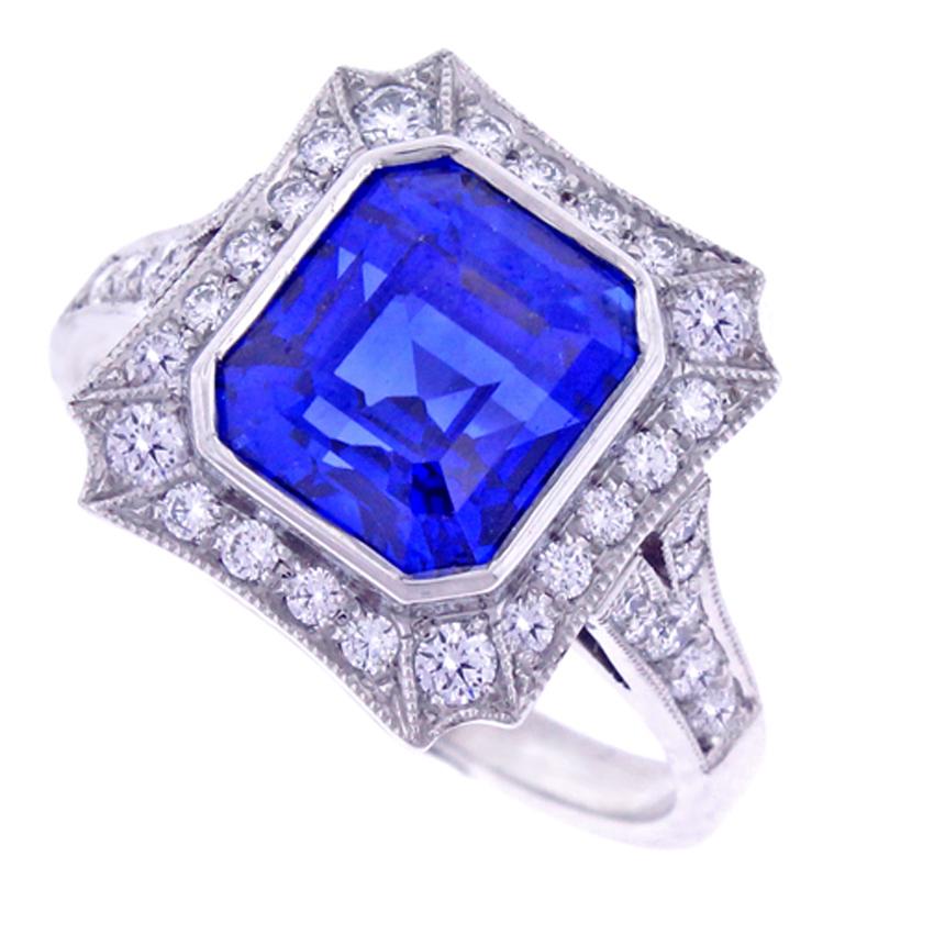 This ring features a center gem emerald cut natural Burma (Myanmar) sapphire weighing 4.40 carats. American Gem Trade Association (AGTA) states the sapphire has no indications of enhancements. There are thirty-six micro pave set modern brilliant cut