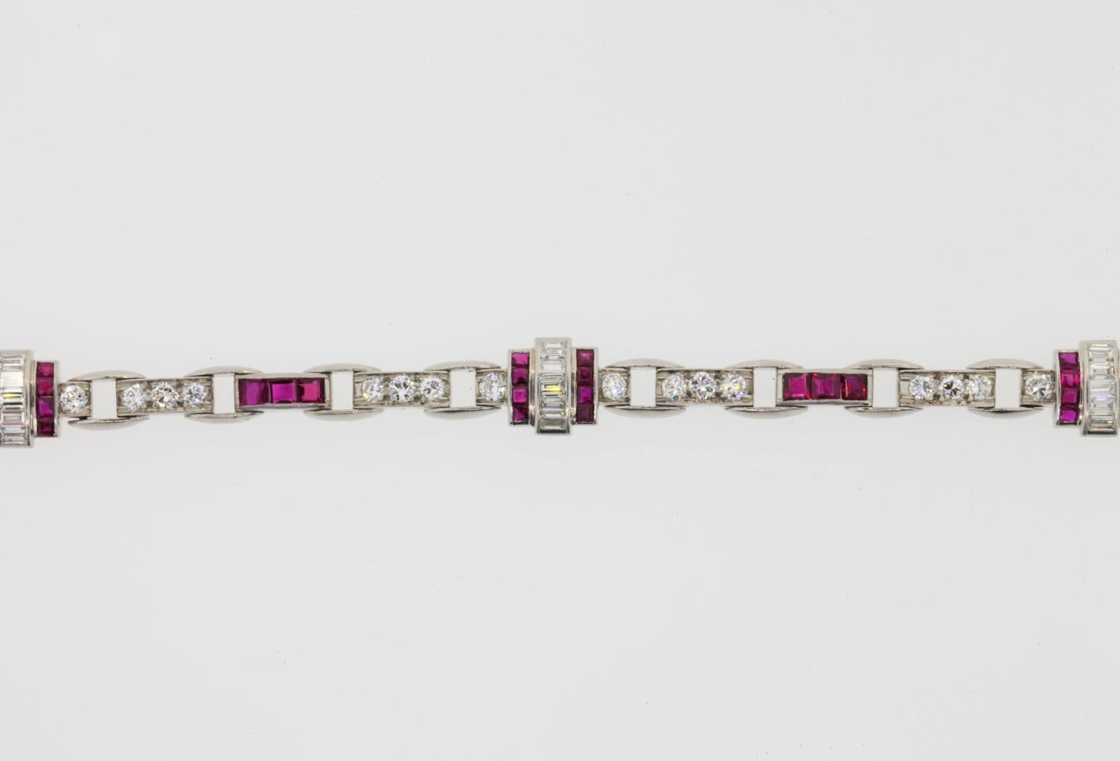 A beautiful 1940s elegant platinum bracelet of alternating stirrup and retro block like links.  Set with 1.20 carats of deep red Burma Rubies and 2.80 carats of Baguette and Transitional cut Diamonds.  All diamonds are of H color - VS1/VS clarity.  