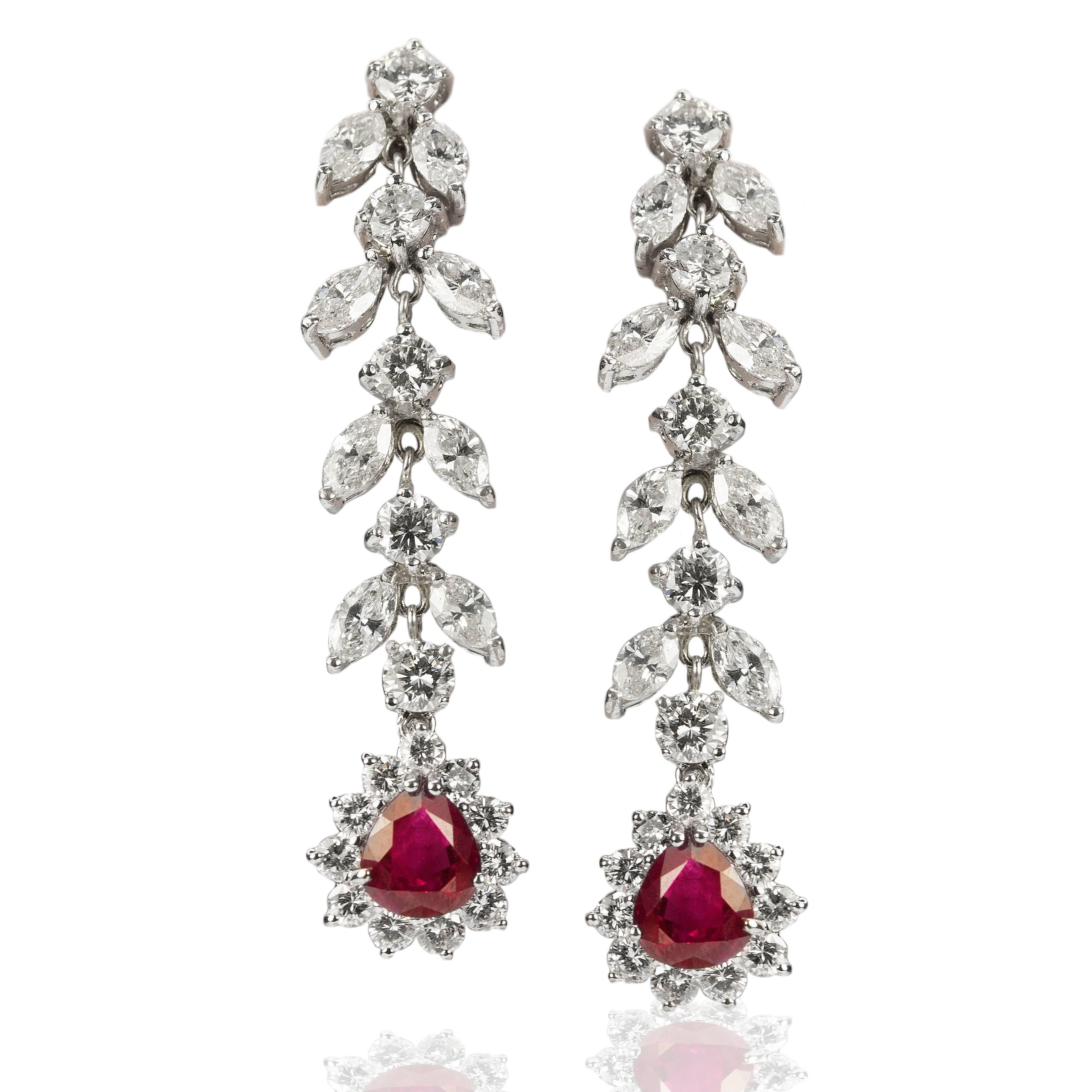 Gorgeous 18K white gold earrings set with 2 pear shape Burma Rubies weighing 2.93 carats and marquis and round brilliant diamonds weighing 6.41 carats total weight.
