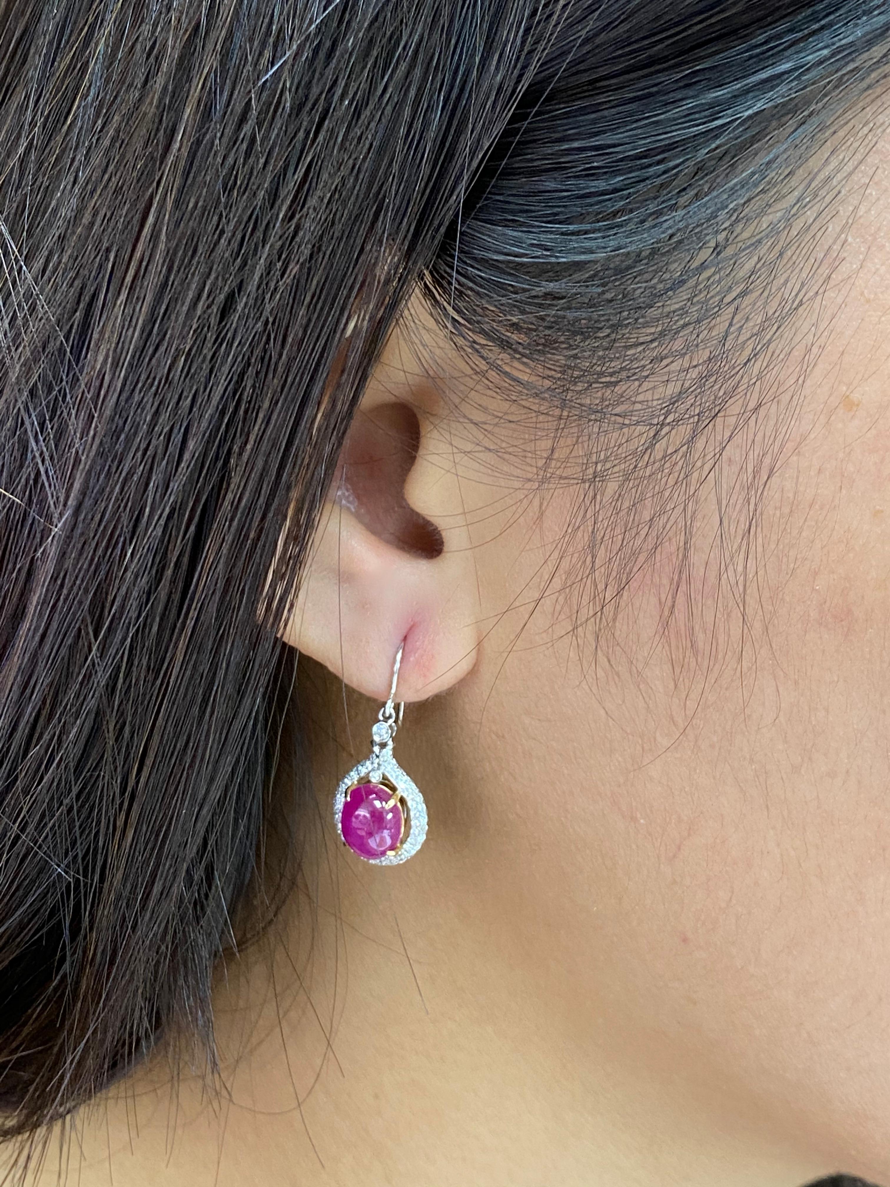 Here is a pair of nice Ruby and diamond earrings. The earrings are set in 18k white gold and white diamonds. There are 2 Burma ruby cabochons totaling 4.98Cts. There are 168 small diamonds totaling 0.63cts in the earrings. The rubies are red-pink in