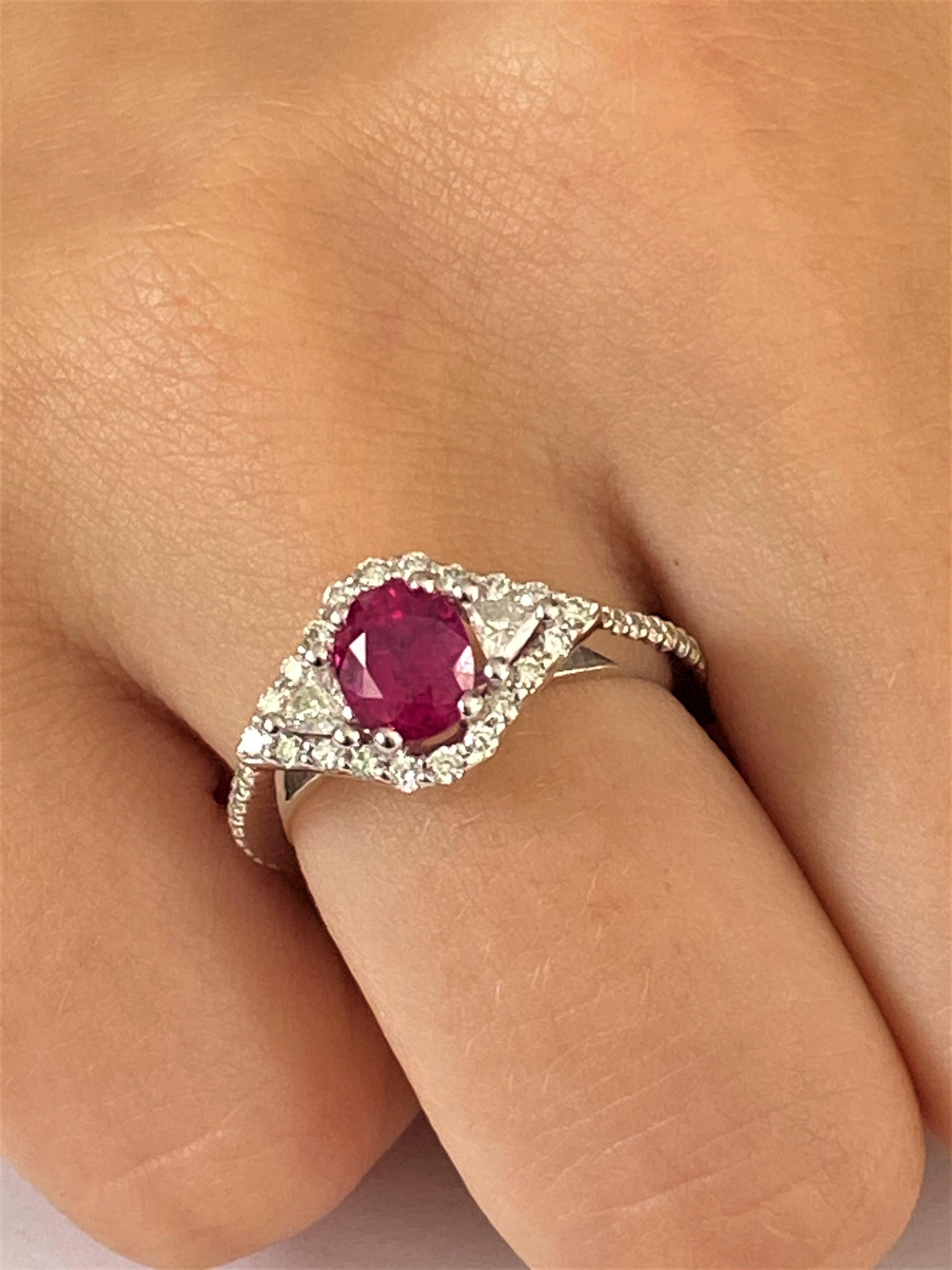 Eighteen karats white gold ruby cocktail ring surrounded two trillion diamonds and melee diamonds 
Ring finger size 7
Diamond carat weight 0.75 
Trillion diamond carat weight 0.25 
Burma Ruby carat total weight 1.07
Ruby hue tone color is rose